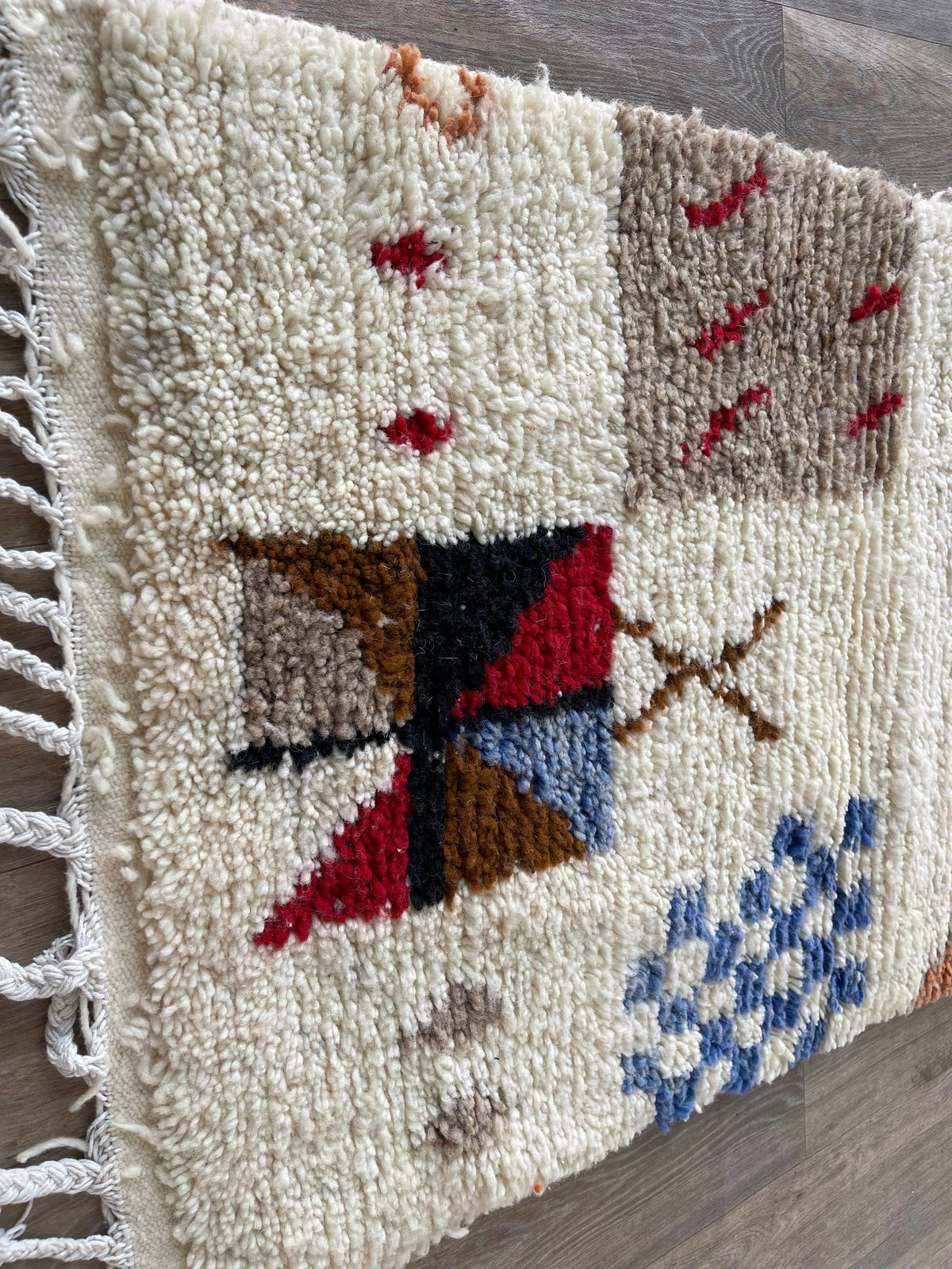 Gros plan sur les franges du tapis de couloir berbère Hazmoud, blanches en bas seulement, nouées à la main