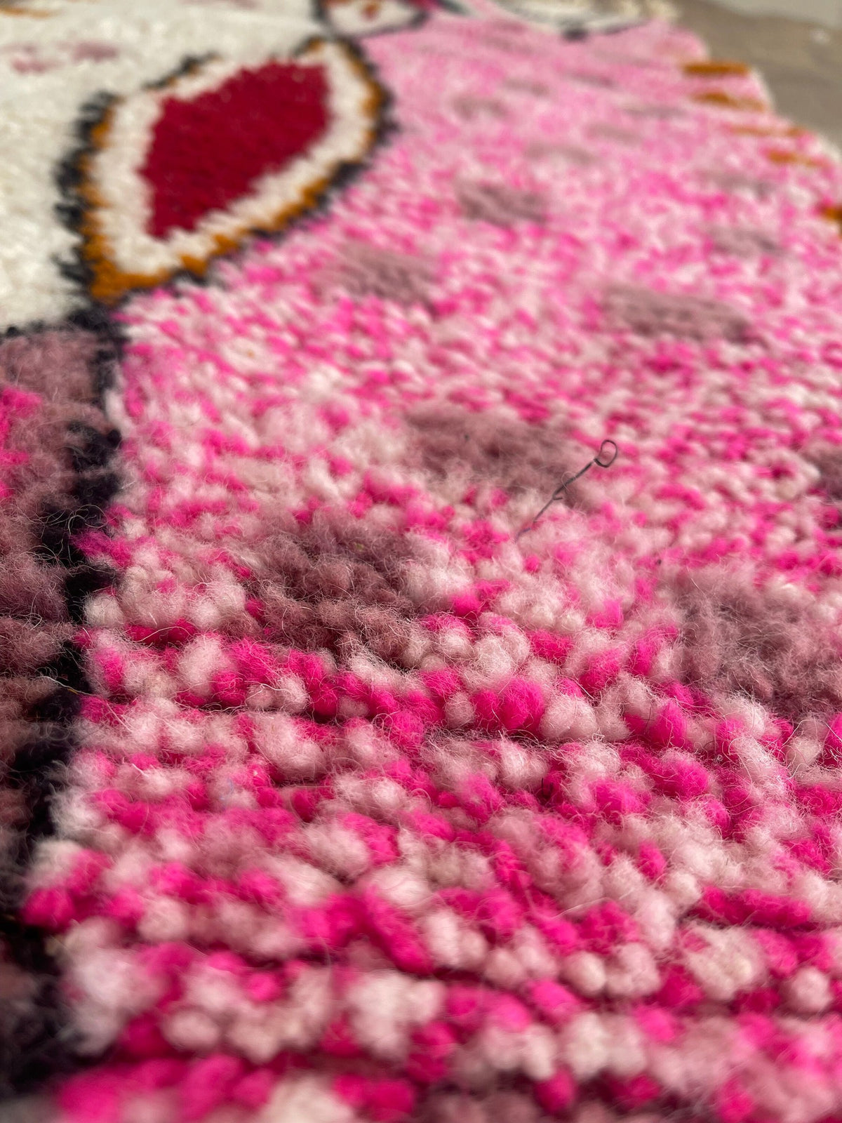 Gros plan sur la laine du tapis de couloir berbère Ameln, laine de mouton au poil moyen, rose et blanche