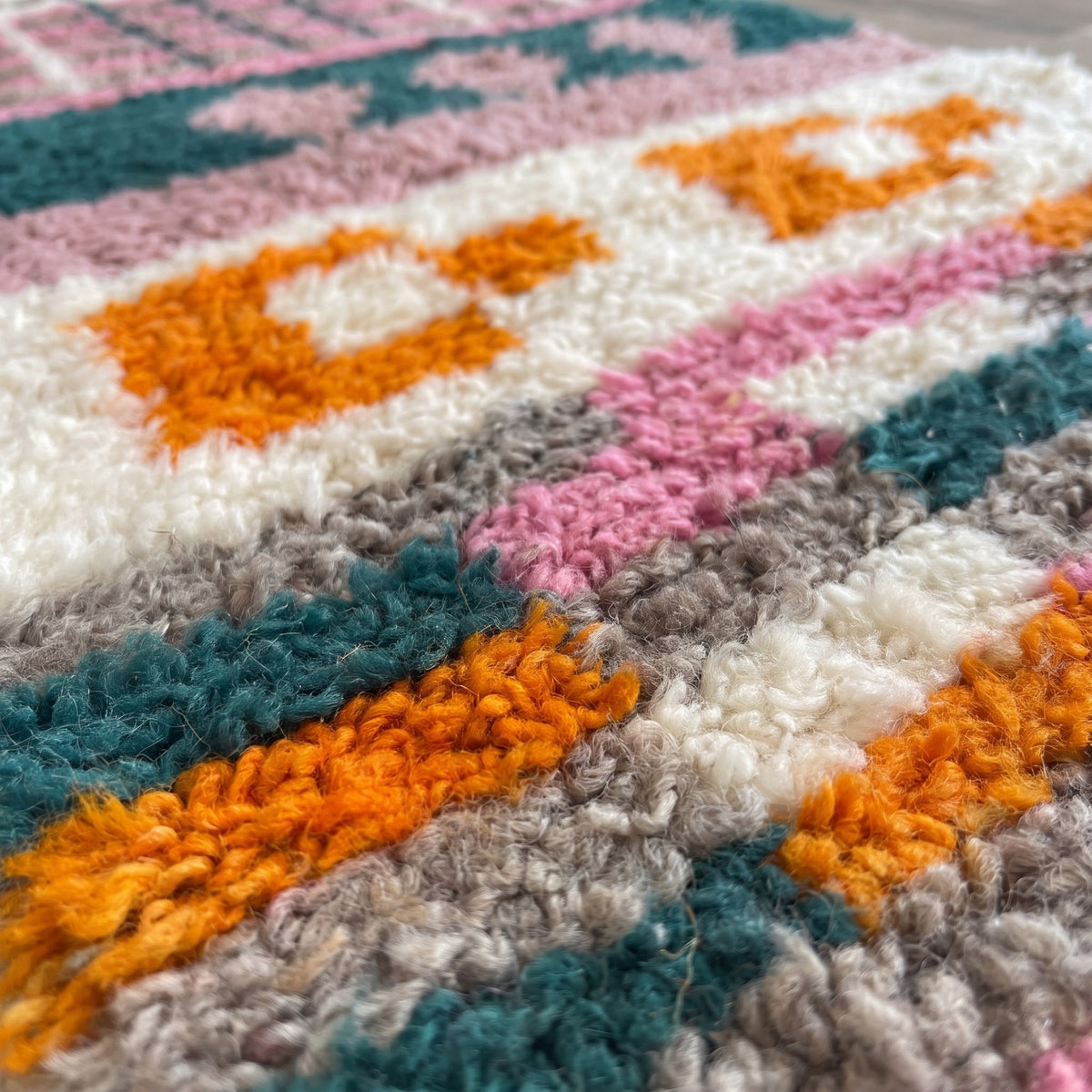 Gros plan sur un motif du tapis de couloir berbère Tikli, couloir écru, en haut figure en sablier vert
