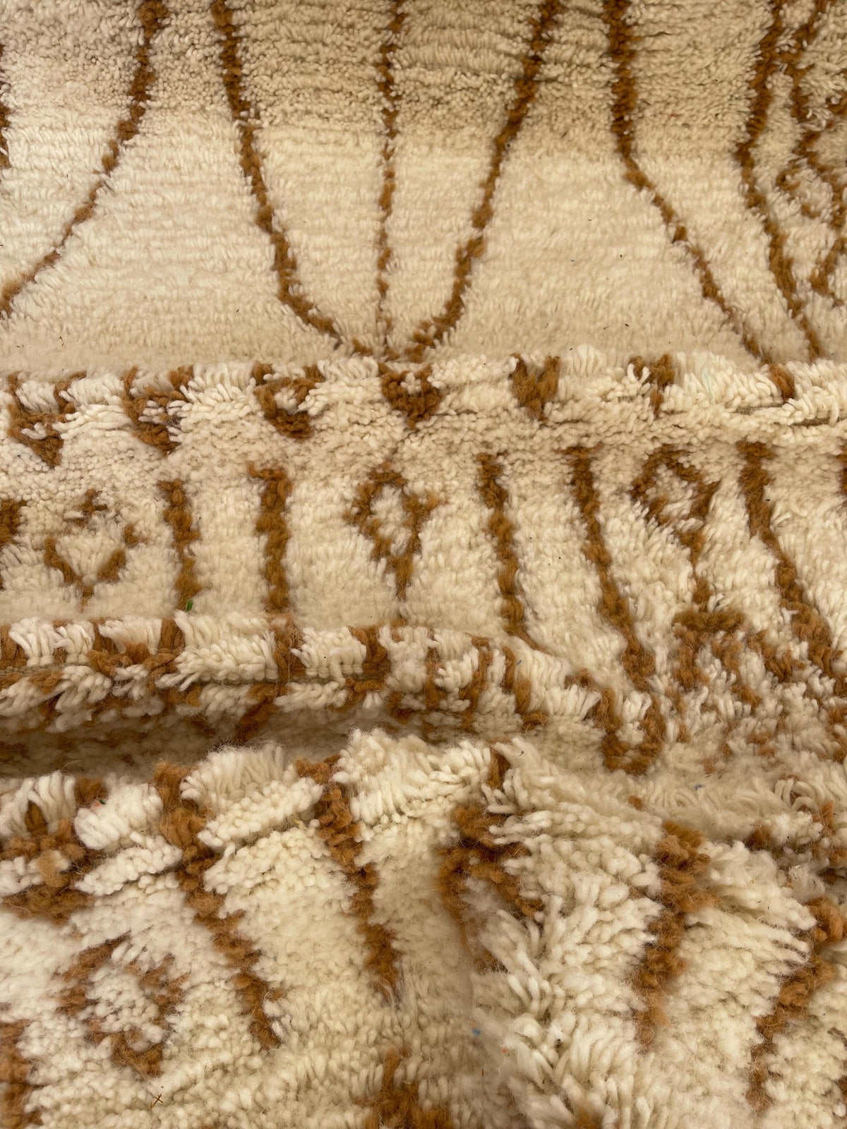 Gros plan sur la laine du tapis de couloir berbère Zemroun, nœuds serrés et tracé du motif de près
