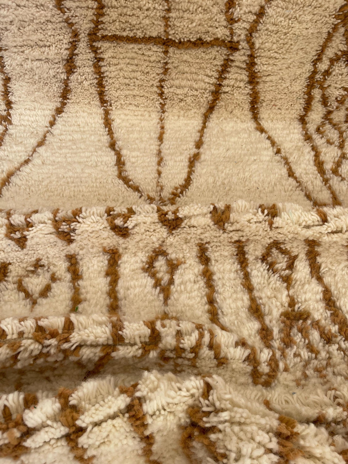 Gros plan sur la laine du tapis de couloir berbère Zemroun, poil blanc et caramel noué à la main