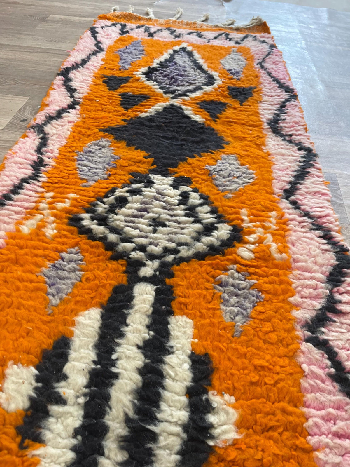 Gros plan sur la laine du tapis de couloir berbère Khamlia, laine de mouton au poil moyen, orange et rose