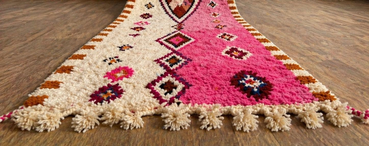 Gros plan sur les franges du tapis de couloir berbère Mazigh, écrues à pompons, nouées à la main