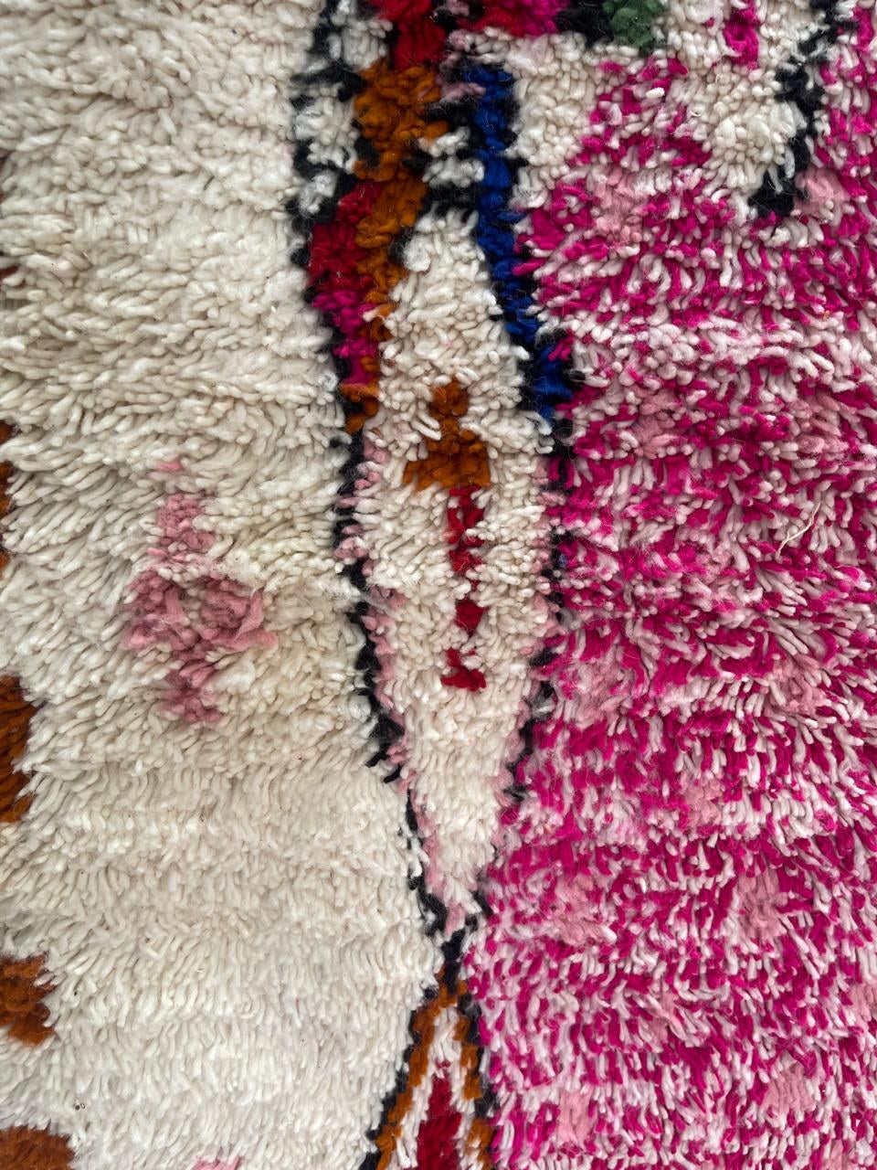 Gros plan sur la laine du tapis de couloir berbère Anoura, laine de mouton au poil long, rose fuchsia