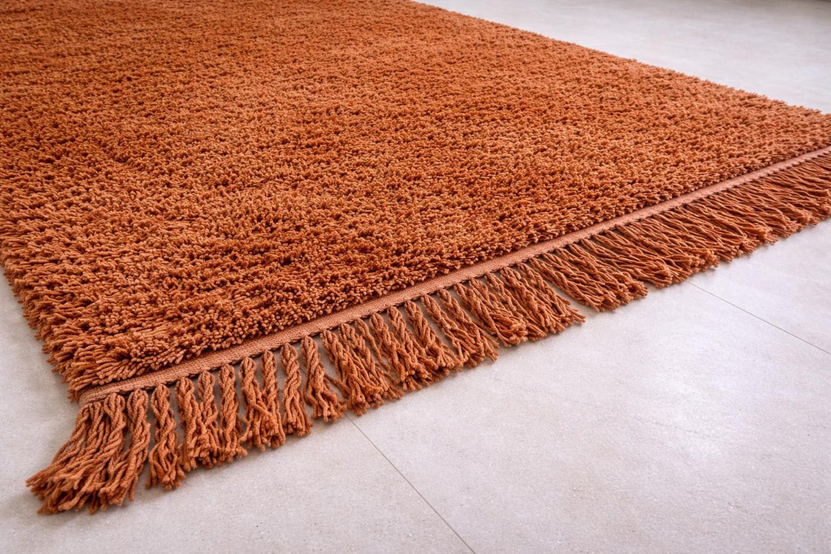 Gros plan sur les franges du tapis de couloir berbère Guercif, brun cognac libres en bas seulement, nouées à la main