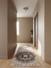Tapis coureur à motifs losanges beiges, marron et crème en étoile, sur parquet clair dans un couloir lumineux