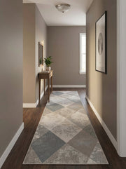 Tapis de couloir moderne à motifs géométriques de losanges délavés gris et beiges, sur un plancher de bois dans un vestibule