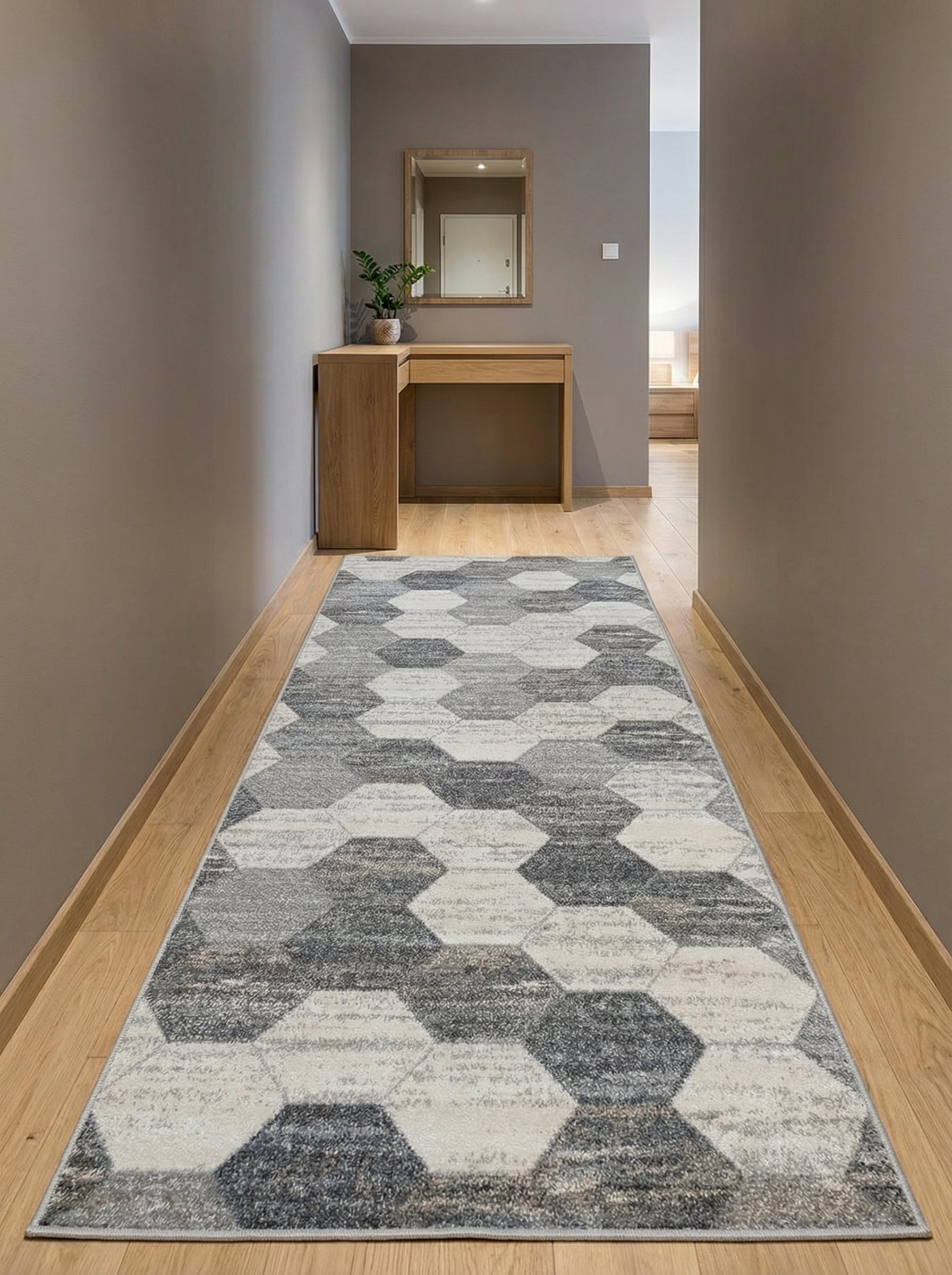 Tapis long aux motifs hexagonaux gris, anthracite et blanc cassé sur un sol en parquet clair dans un couloir moderne