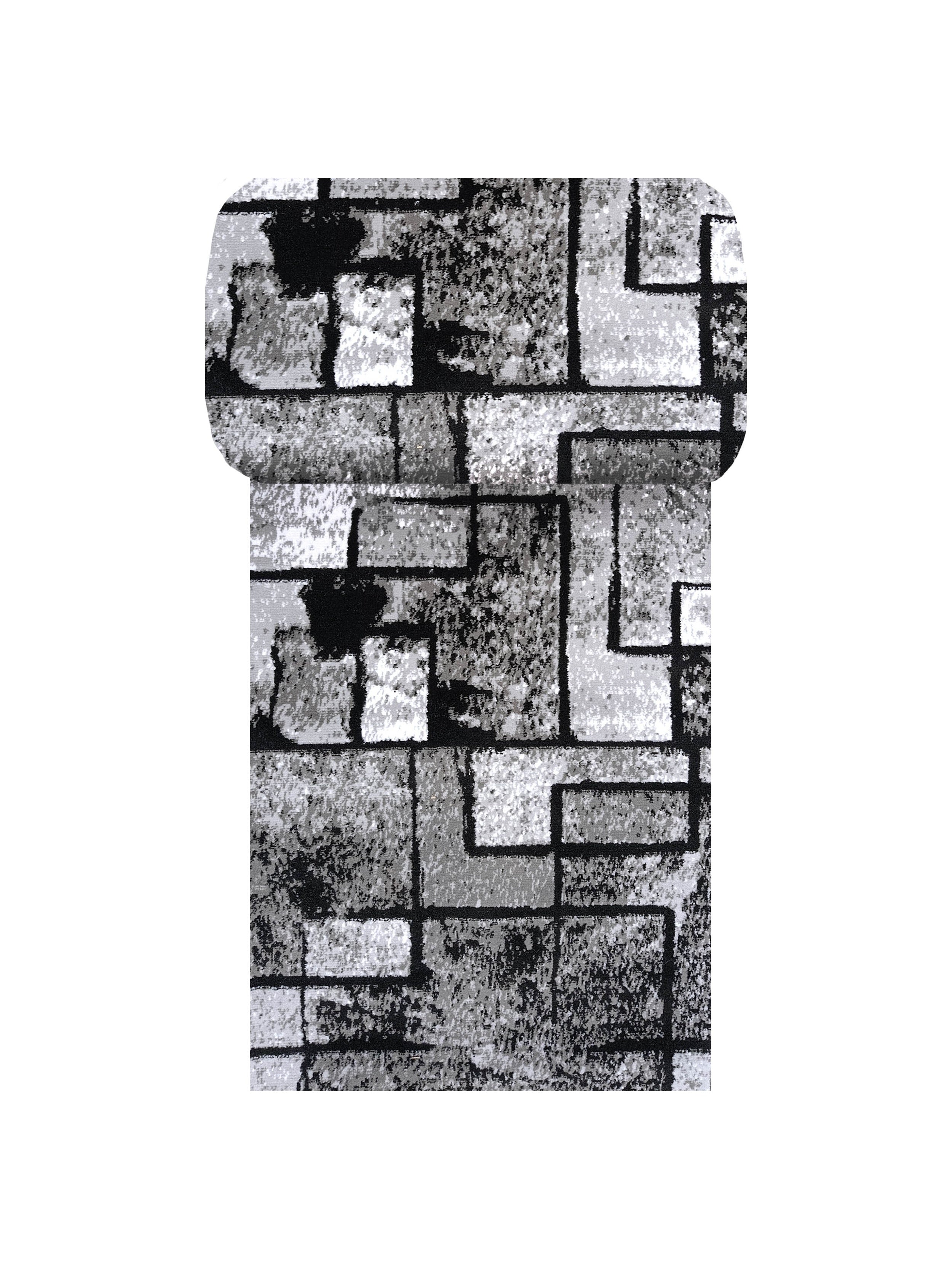 Un rouleau de tissu présentant un motif géométrique de carrés et rectangles noirs, gris et blancs tachetés