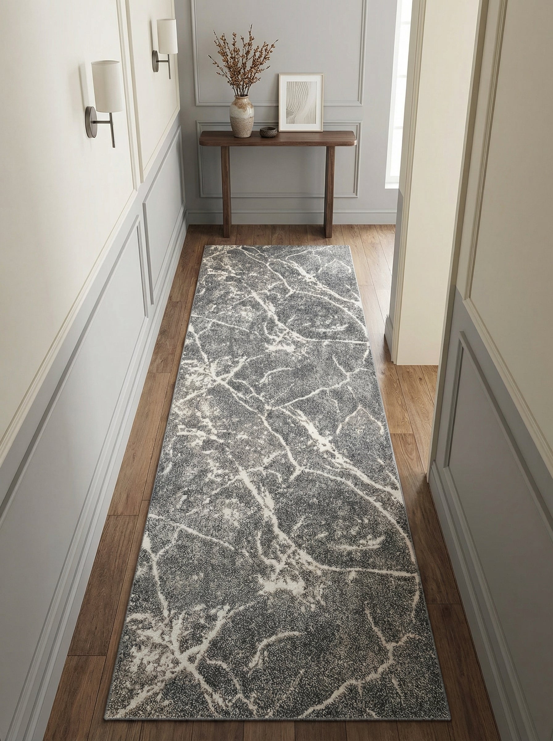 Tapis de couloir long gris foncé avec des motifs sinueux blancs évoquant le marbre, sur un parquet clair dans une entrée