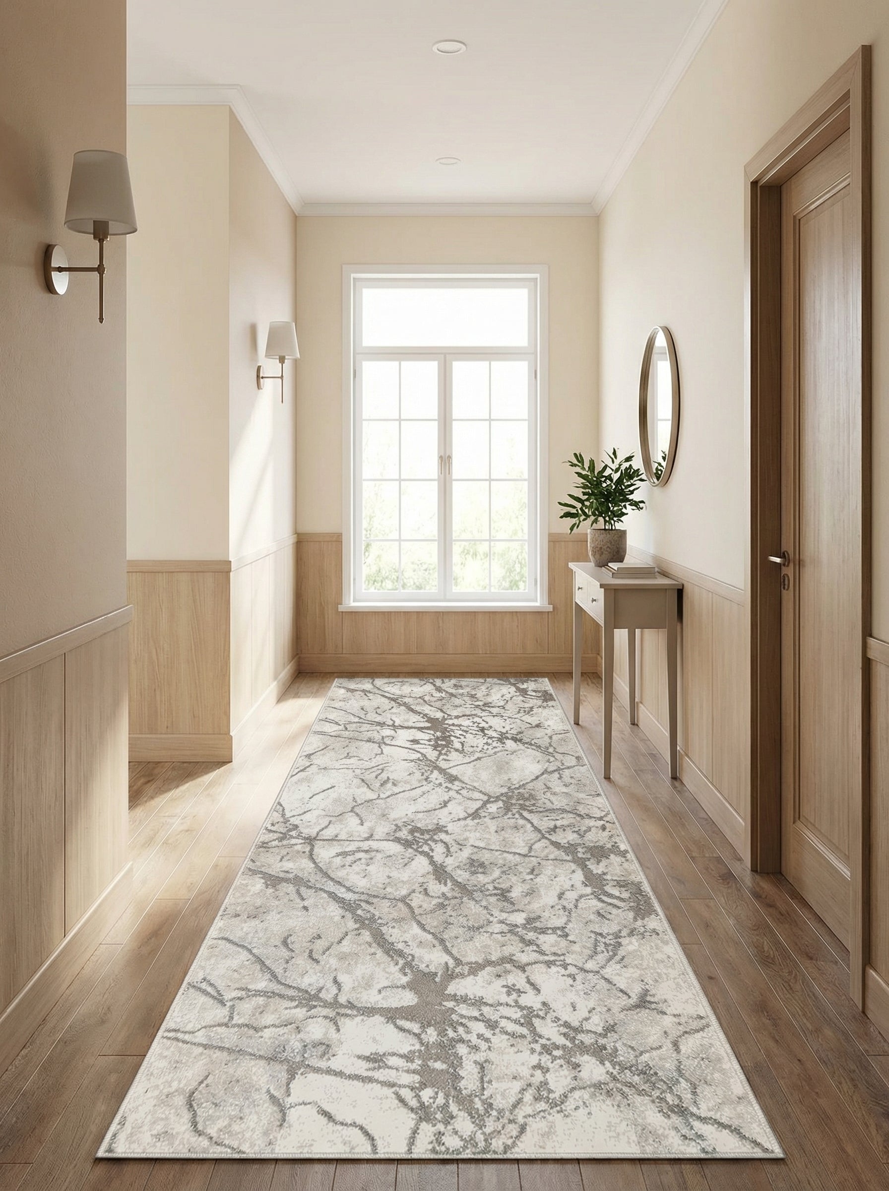 Long tapis de couloir crème aux motifs abstraits gris foncé évoquant des branches, sur un plancher en bois dans une entrée lumineuse