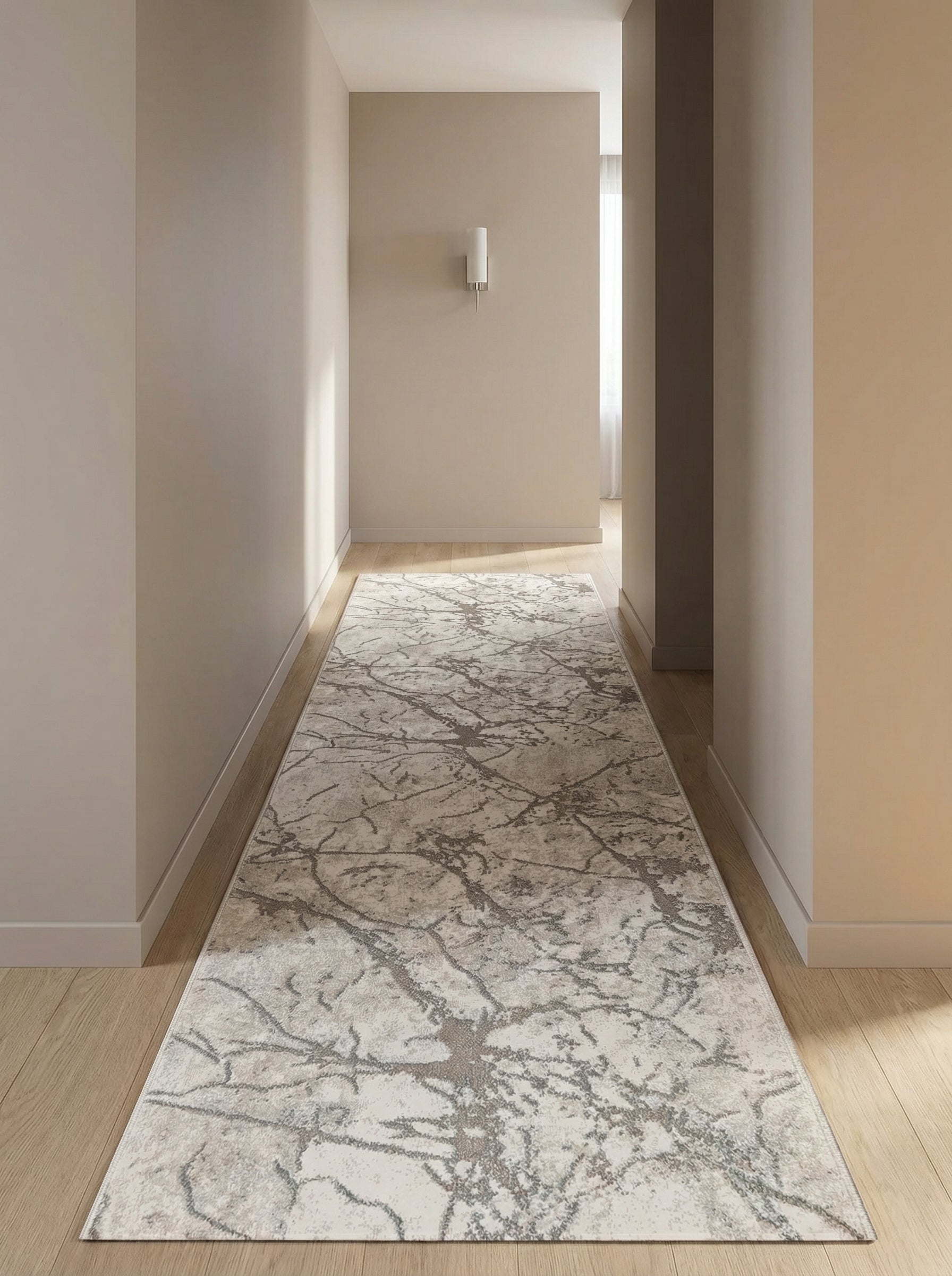Tapis couloir beige et gris foncé à motifs abstraits veinés type marbre, sur parquet clair dans un couloir lumineux