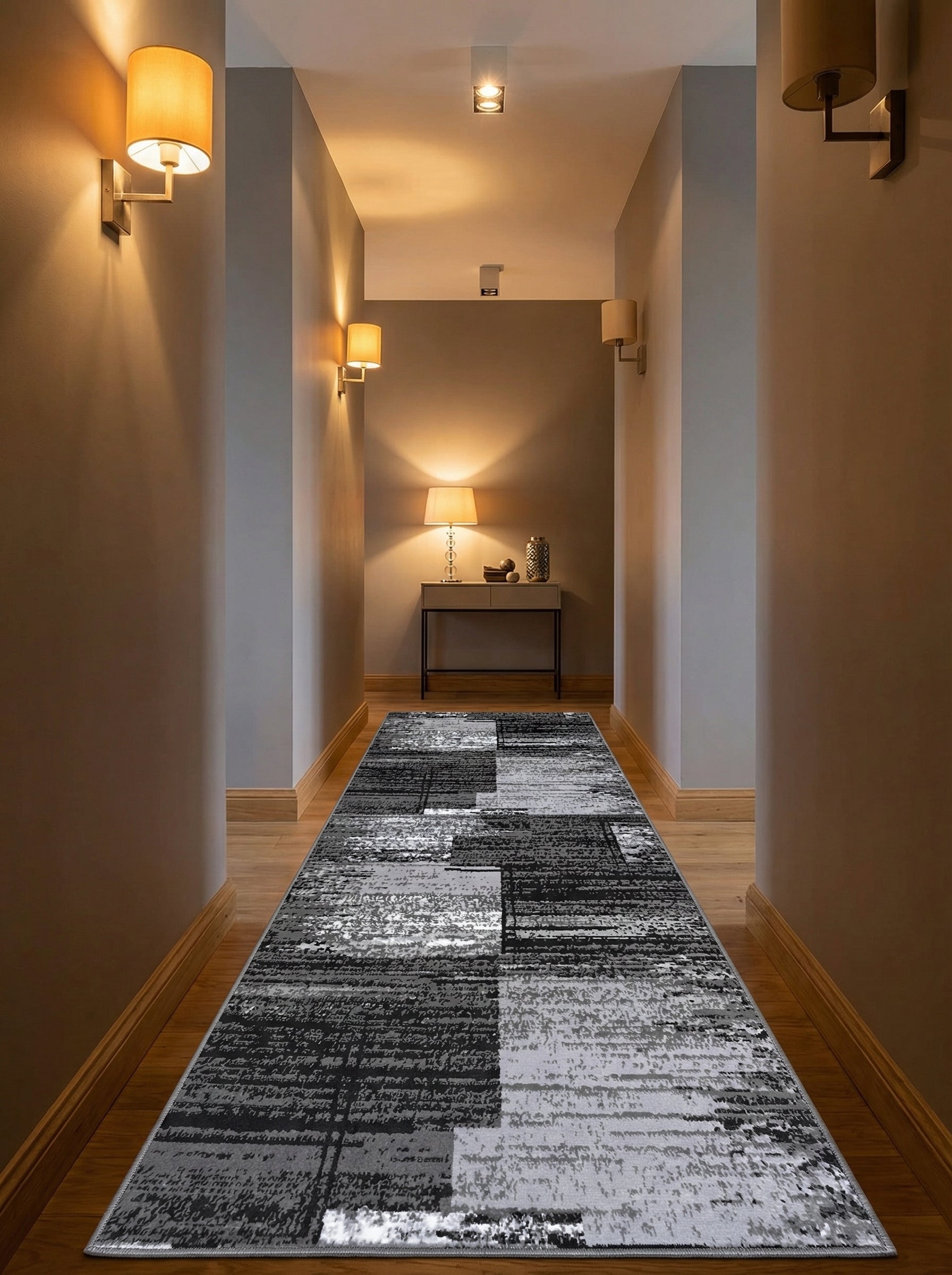 Long tapis de couloir rectangulaire aux motifs abstraits et texturés en noir, gris et blanc, posé sur un parquet dans une entrée lumineuse