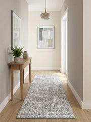 Tapis de couloir gris et blanc aux motifs abstraits et texturés sur un parquet, dans une entrée moderne et lumineuse