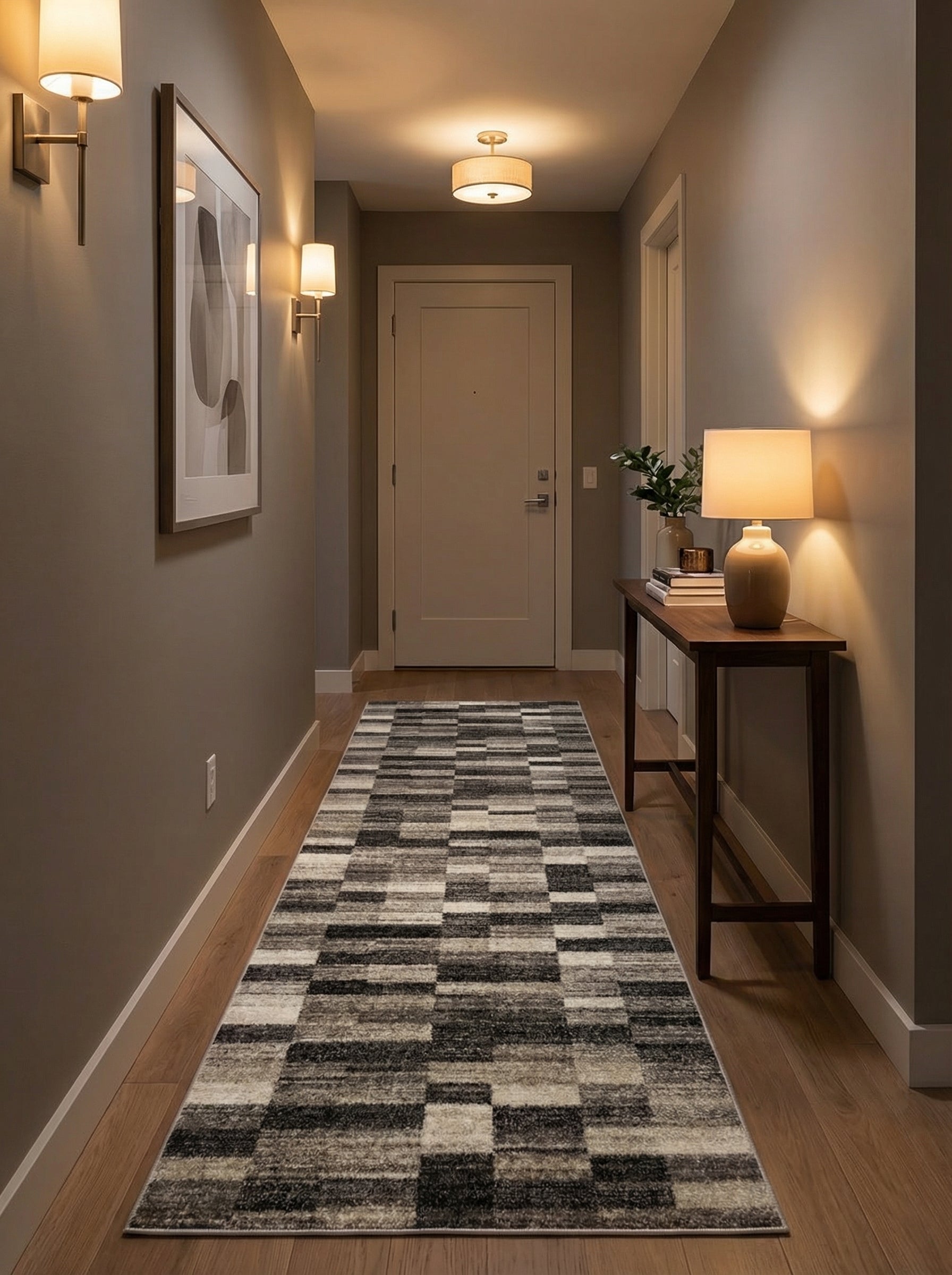 Tapis de couloir long aux motifs géométriques rectangulaires noirs, gris et blancs, posé sur un sol en parquet d'un couloir moderne