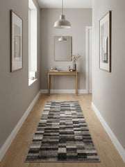 Tapis coureur gris et noir à motifs géométriques abstraits de rectangles texturés sur un parquet clair dans un couloir moderne