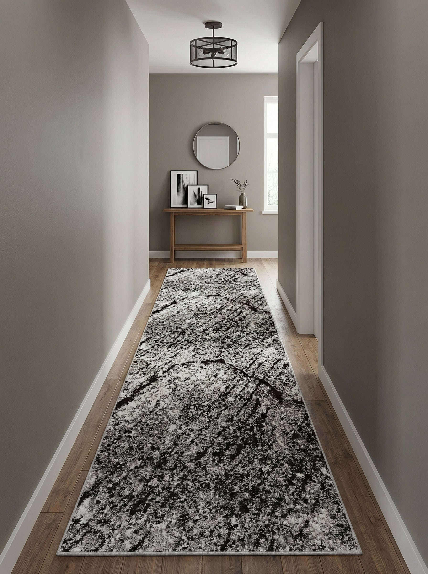 Tapis de couloir aux motifs abstraits noirs, blancs et gris posé sur un parquet en bois dans une entrée