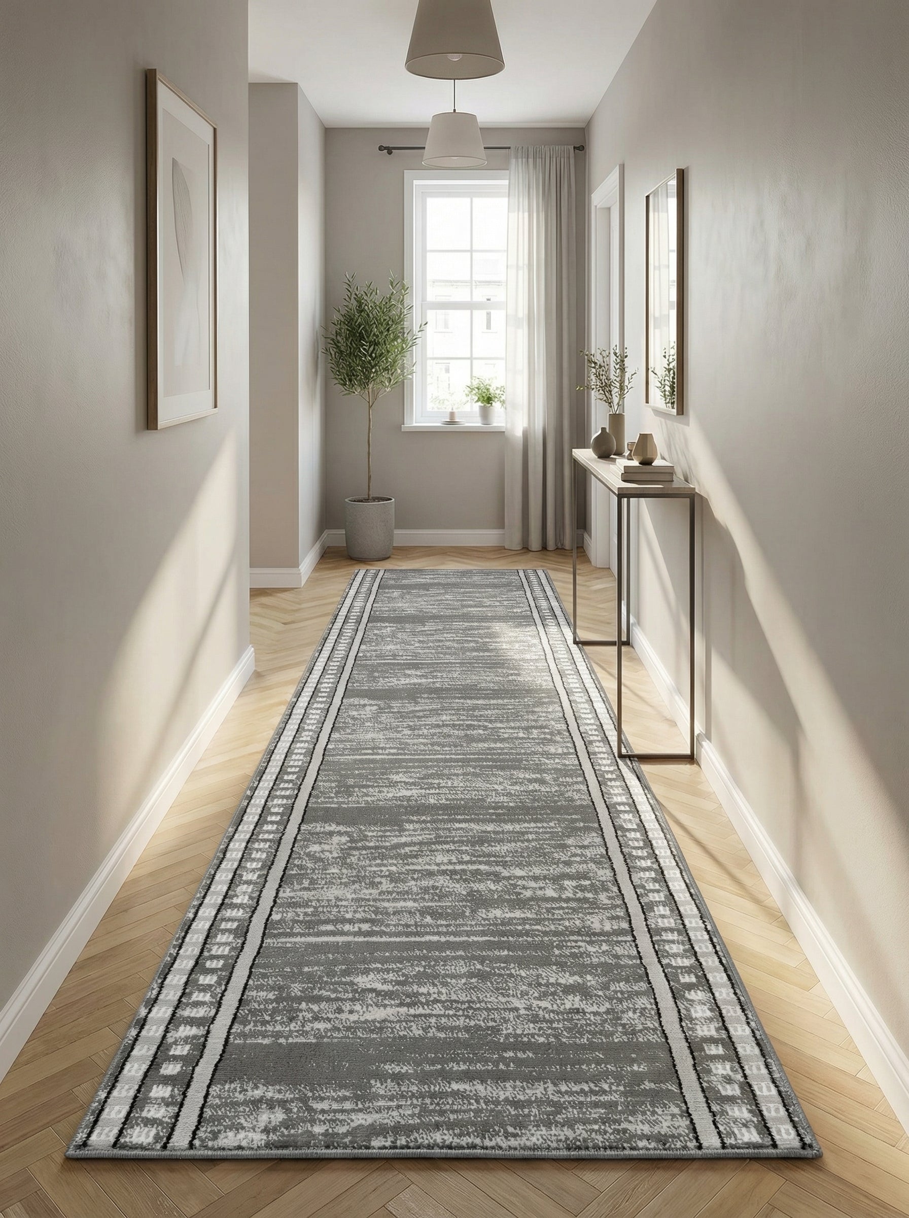 Tapis de couloir gris à motifs abstraits délavés blancs et bordures géométriques noires et blanches, posé sur un parquet clair dans un long couloir moderne et lumineux