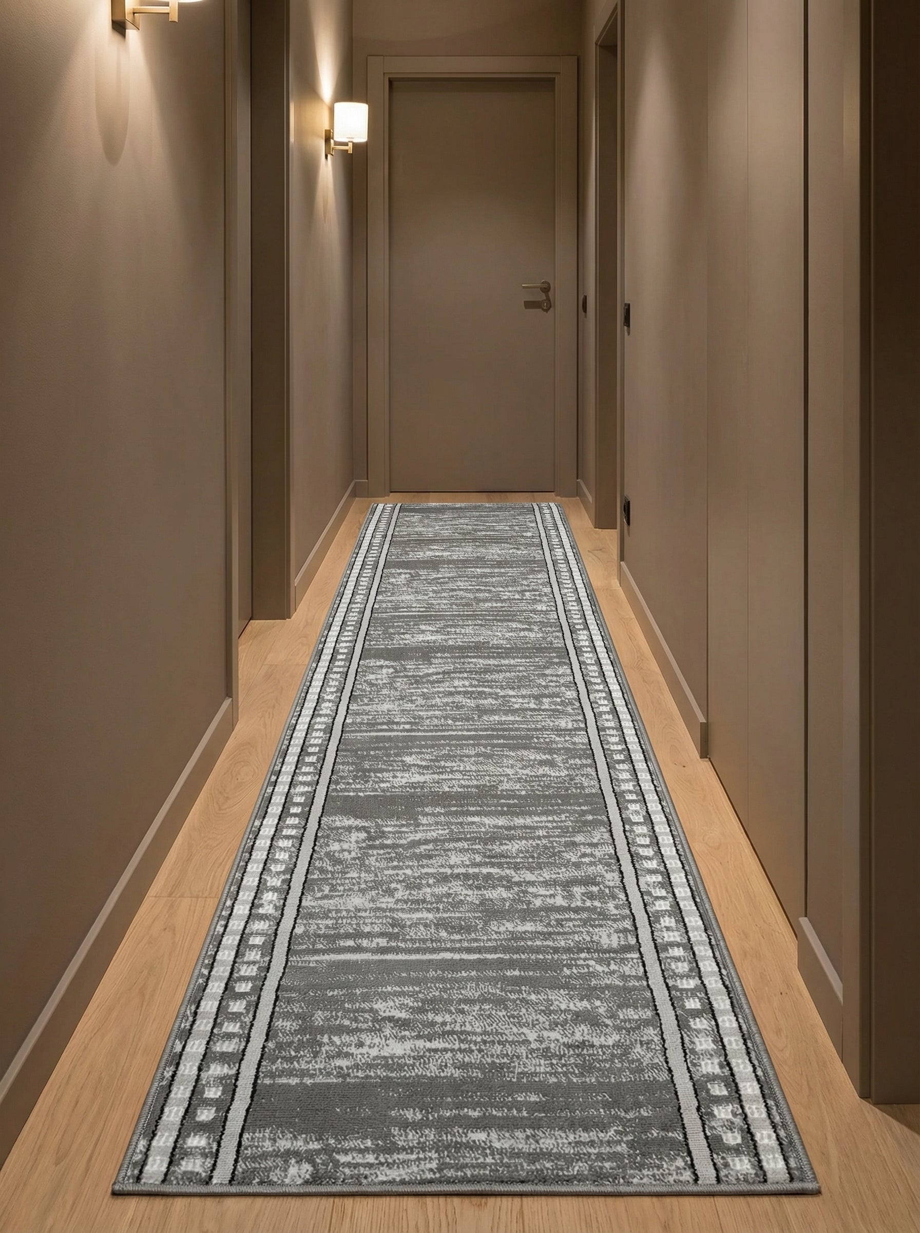 Long tapis de couloir gris aux motifs abstraits brossés blancs et bordures géométriques, sur parquet clair dans un couloir