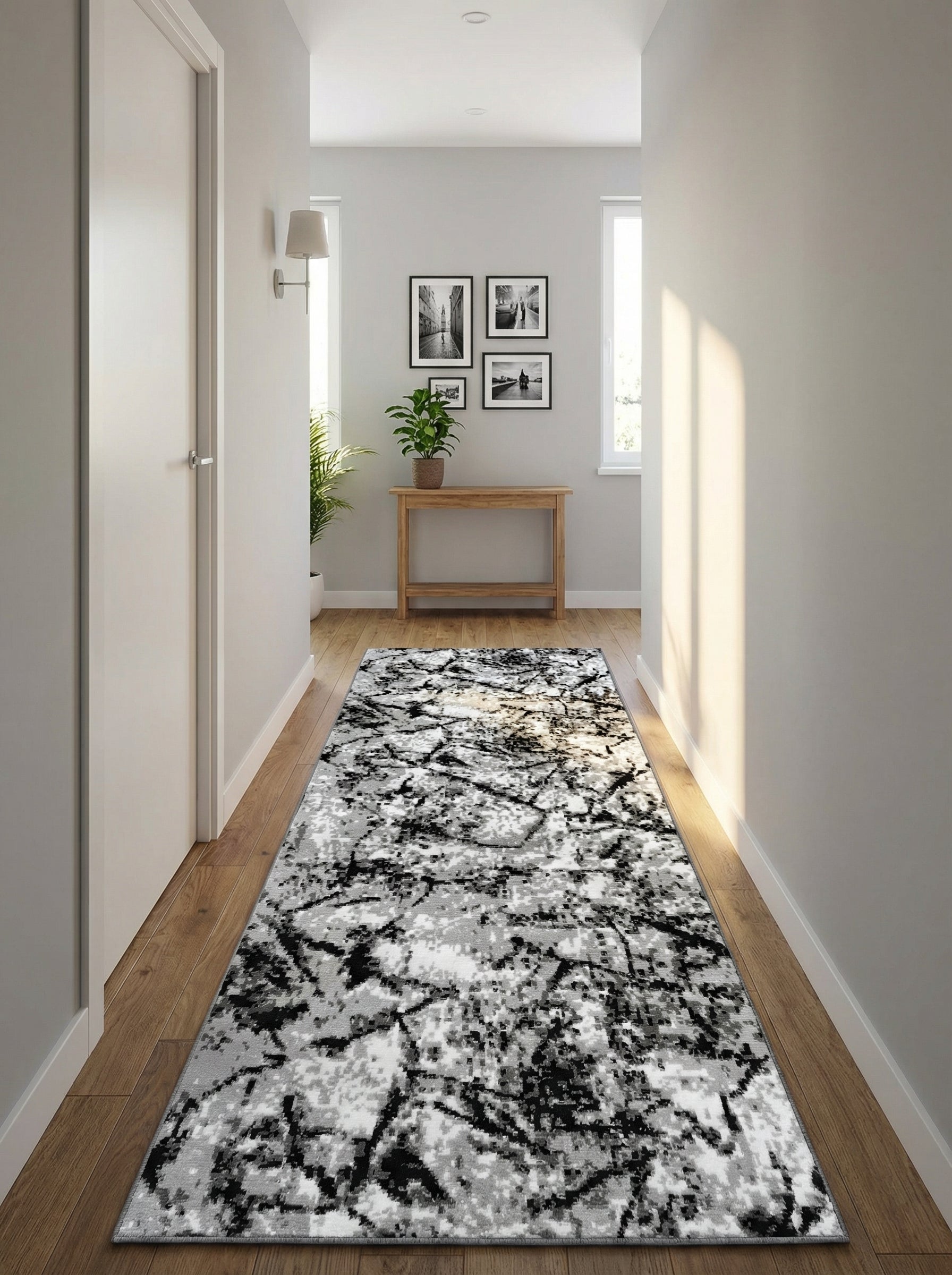Long tapis de couloir noir, blanc et gris aux motifs abstraits et pixelisés, posé sur un parquet en bois dans une entrée lumineuse