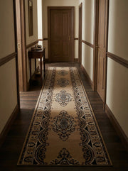 Long tapis beige clair à motifs traditionnels ornementaux marron foncé et crème dans un couloir boisé