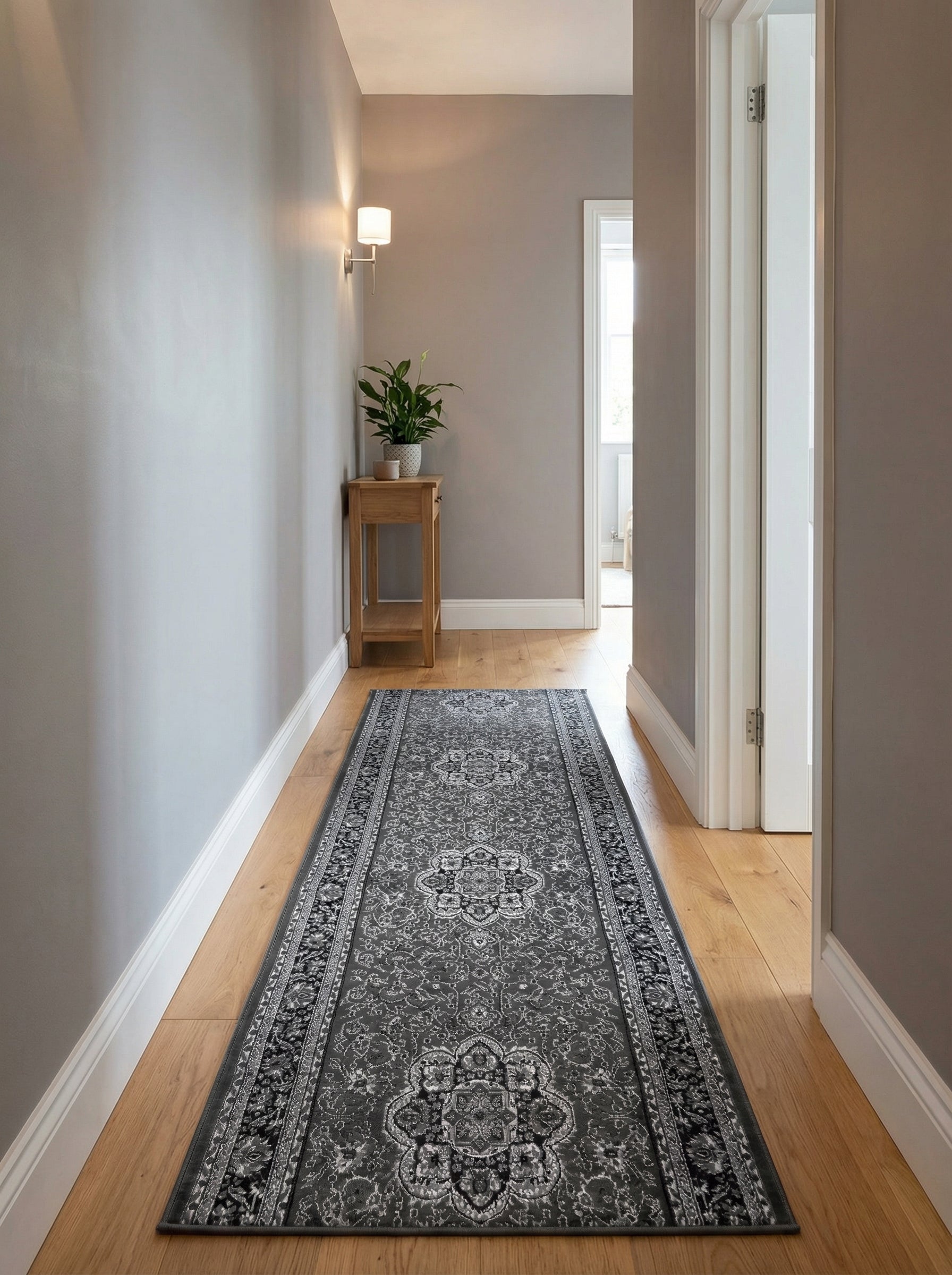 Tapis de couloir gris foncé à motifs ornementaux tissés en gris clair et noir, sur parquet dans un couloir