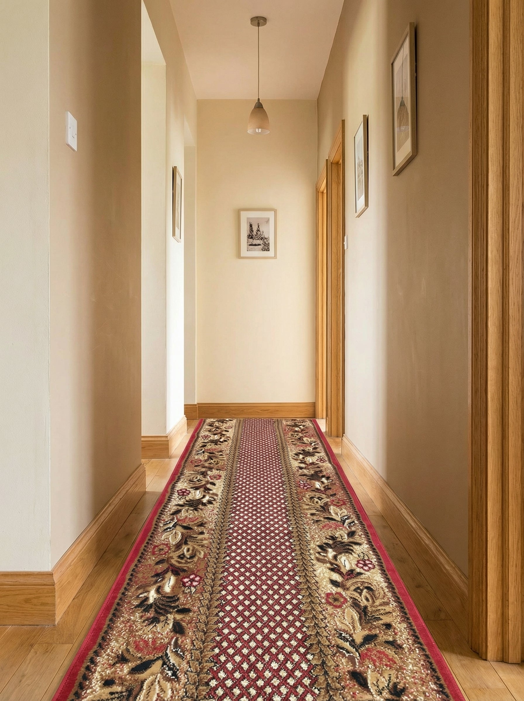 Tapis de couloir rouge avec motifs floraux beiges et noirs et un centre géométrique, dans un long couloir