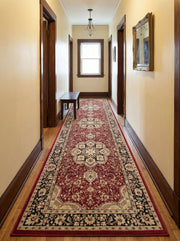 Long tapis de couloir rouge bordeaux aux motifs floraux et ornementaux crèmes et noirs sur parquet dans un hall