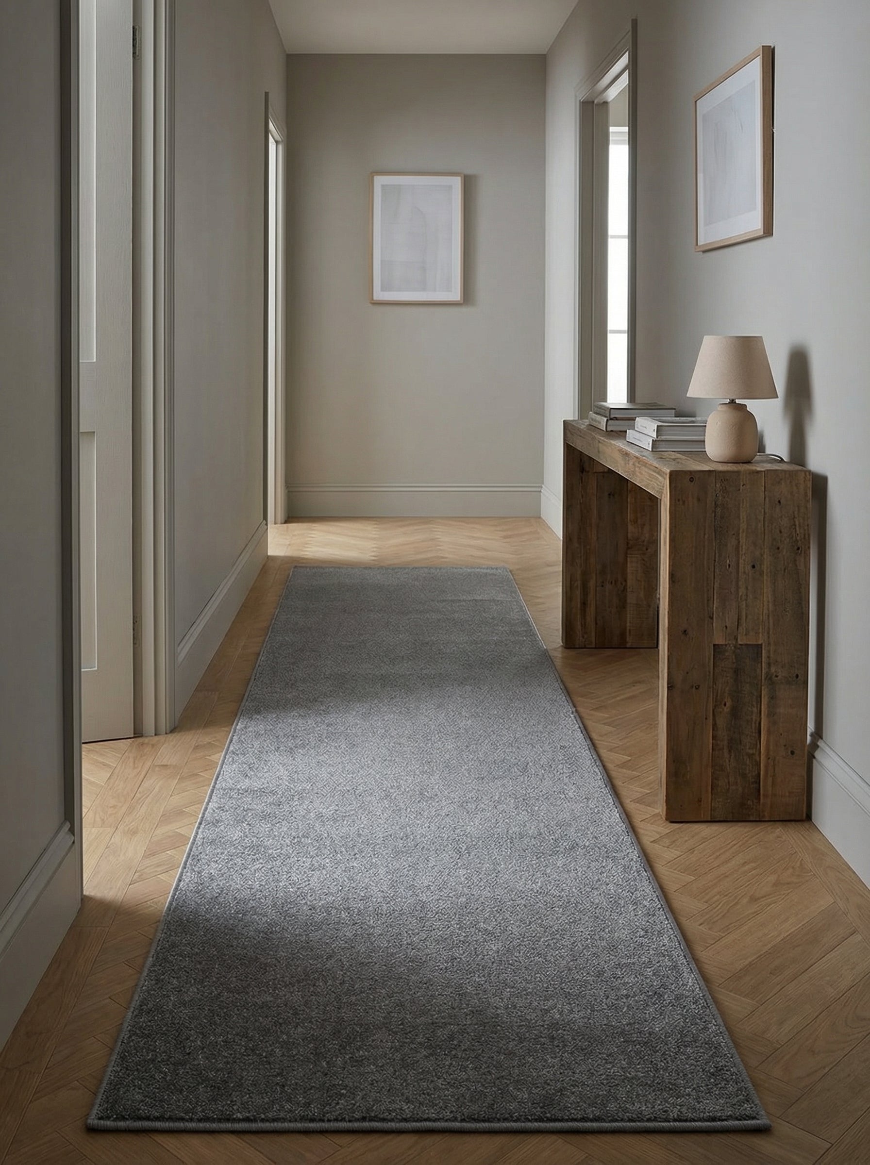 Tapis de couloir gris anthracite, long et rectangulaire, avec un motif tissé subtil, posé sur un parquet clair dans une entrée élégante