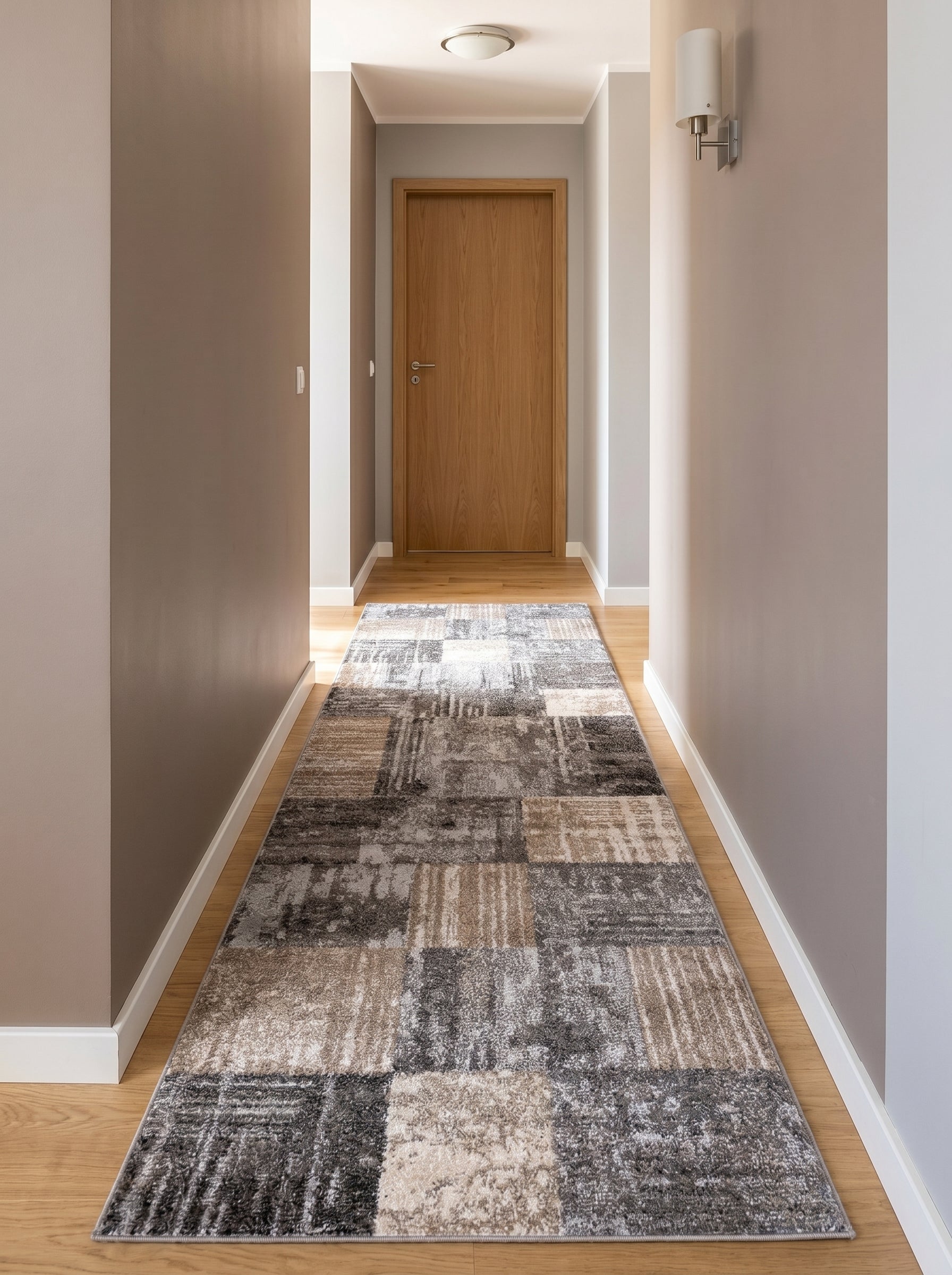 Tapis rectangulaire à motifs patchwork gris, beige et crème dans un couloir