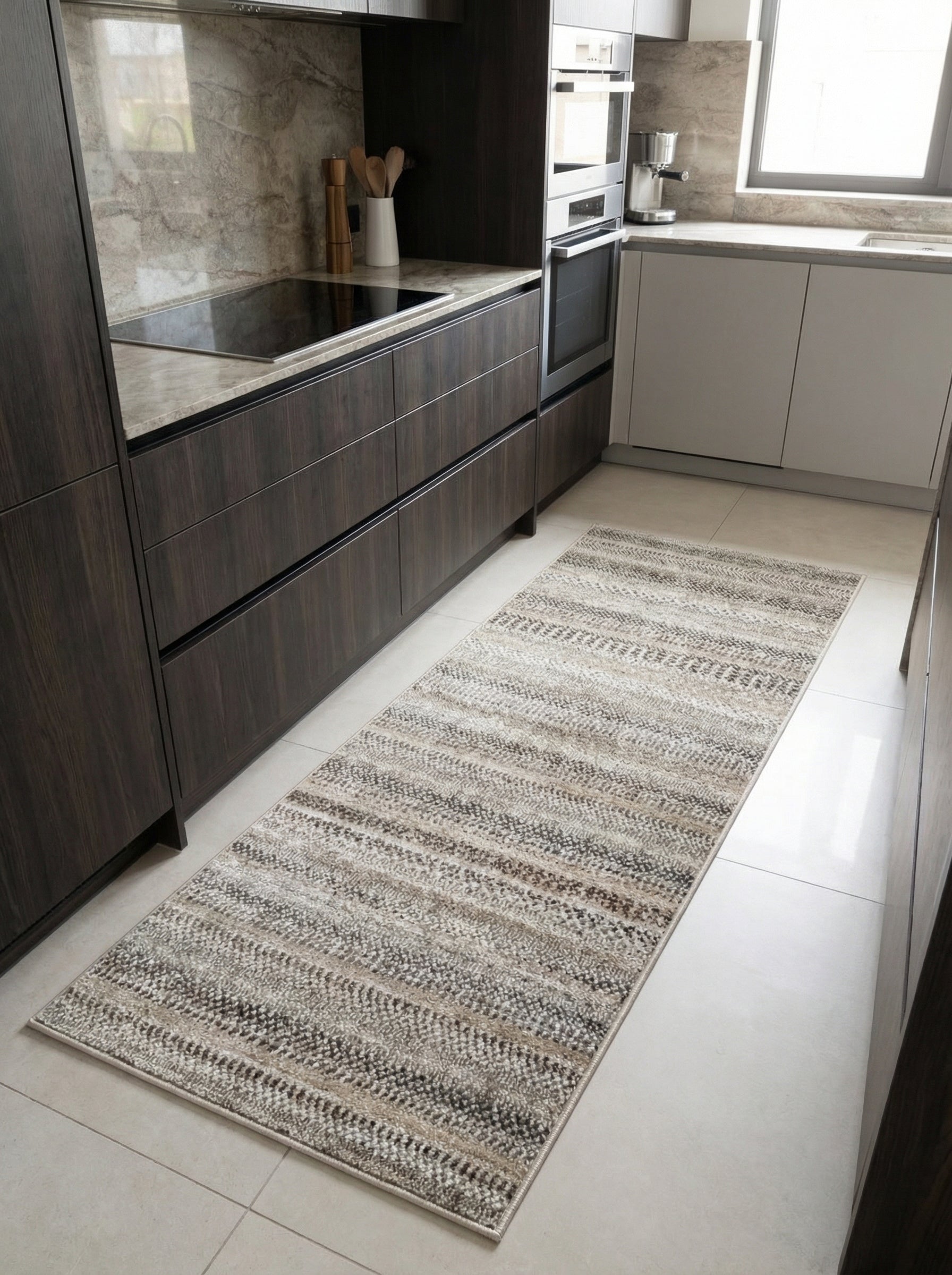 Tapis de couloir aux bandes texturées en tons de beige, crème et gris anthracite, posé sur le carrelage d'une cuisine
