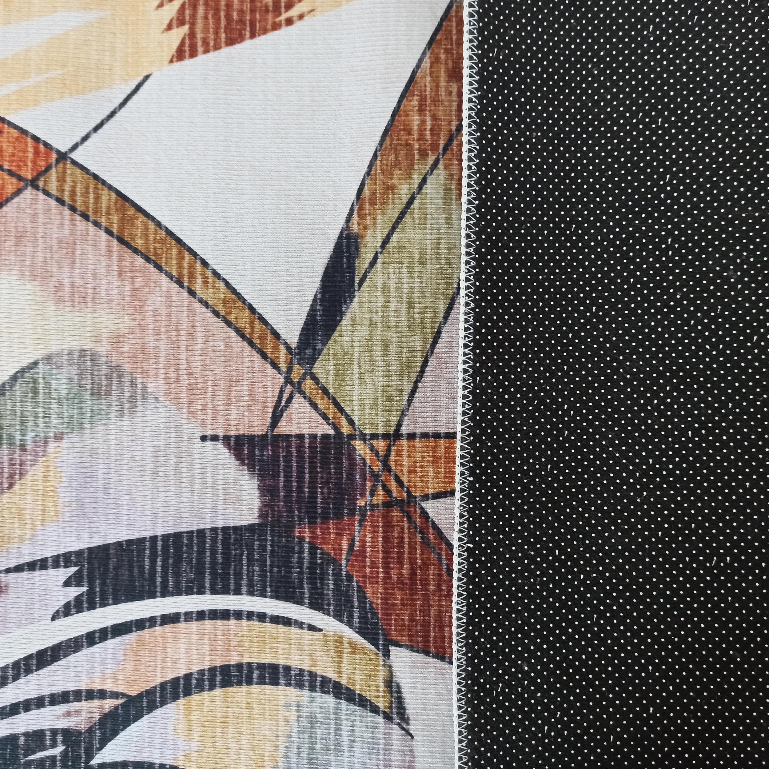 Tapis avec un côté supérieur aux motifs abstraits géométriques multicolores et un dessous noir antidérapant à pois blancs