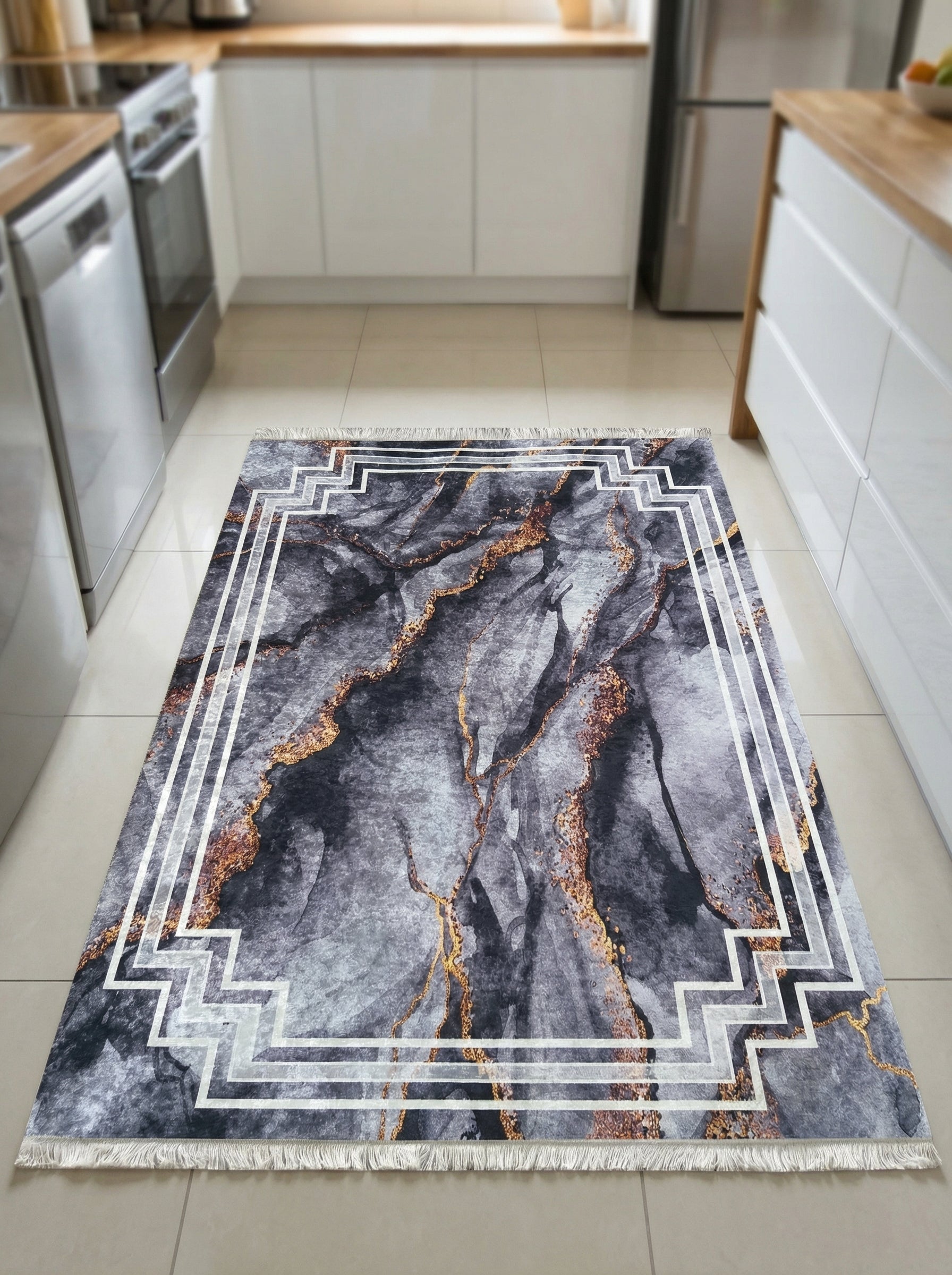Tapis rectangulaire à motifs marbrés gris foncé et or, encadré d'une bordure géométrique blanche, dans une cuisine moderne