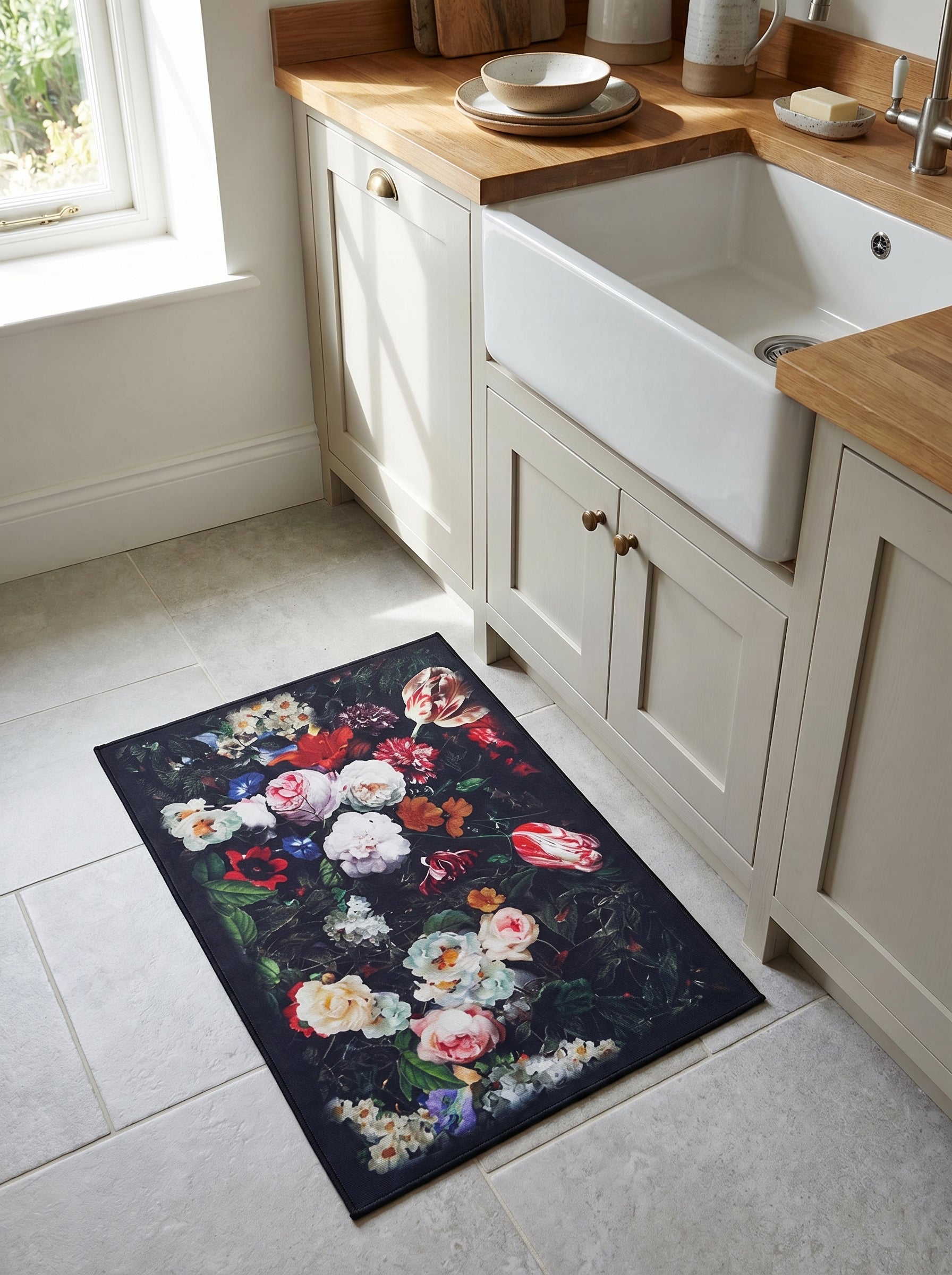 Tapis rectangulaire aux motifs floraux vifs sur fond sombre, avec roses et tulipes, posé sur un carrelage clair dans une cuisine