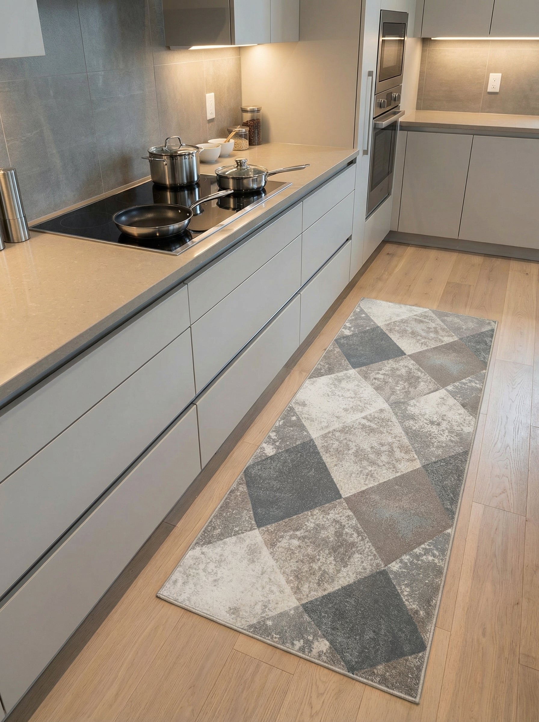 Tapis de couloir géométrique aux losanges gris, beiges et crème, certains effet usé, sur parquet clair dans une cuisine moderne