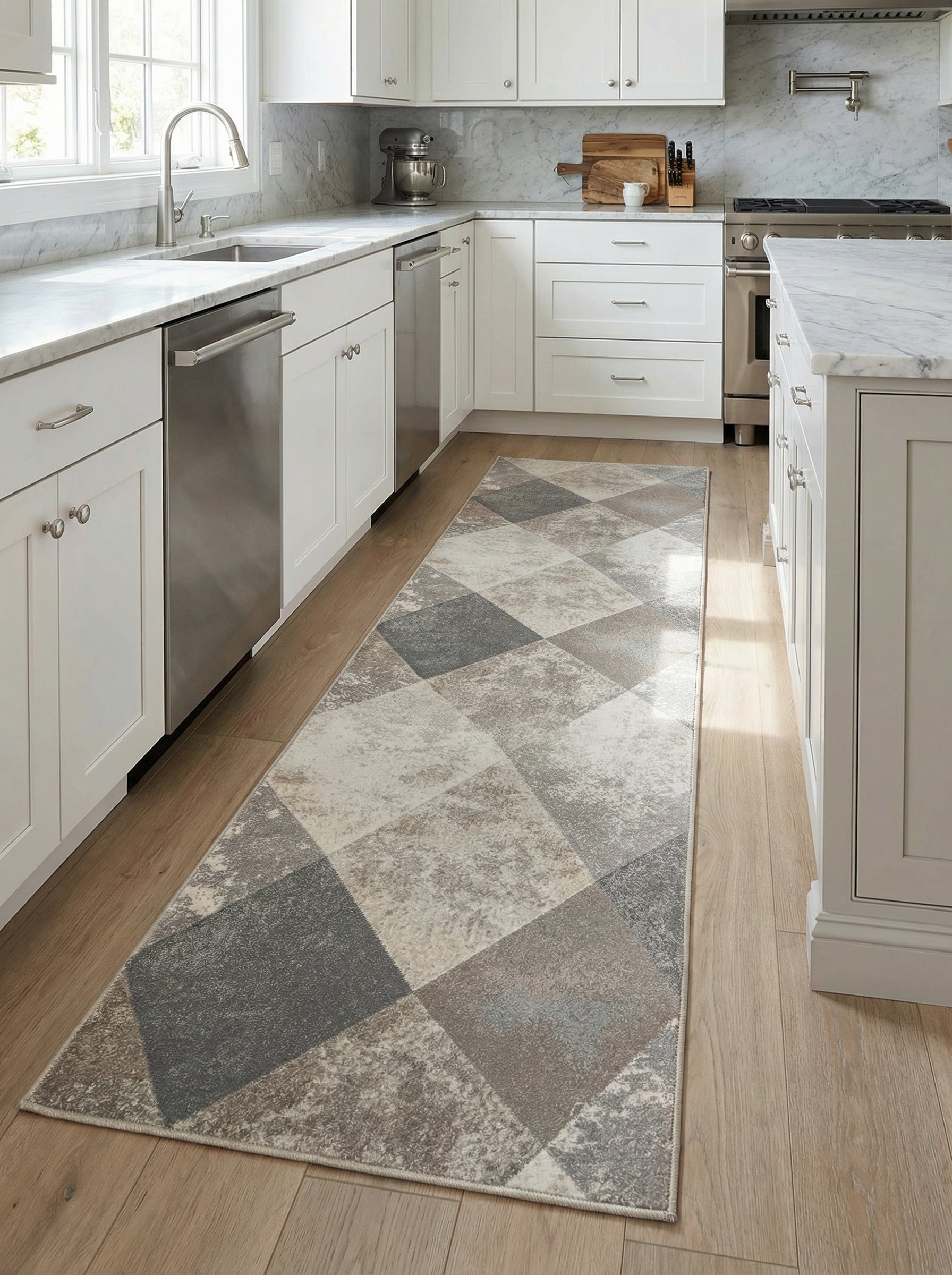 Tapis rectangulaire à motifs géométriques gris, beige et blanc cassé, avec un aspect patiné, posé dans une cuisine moderne