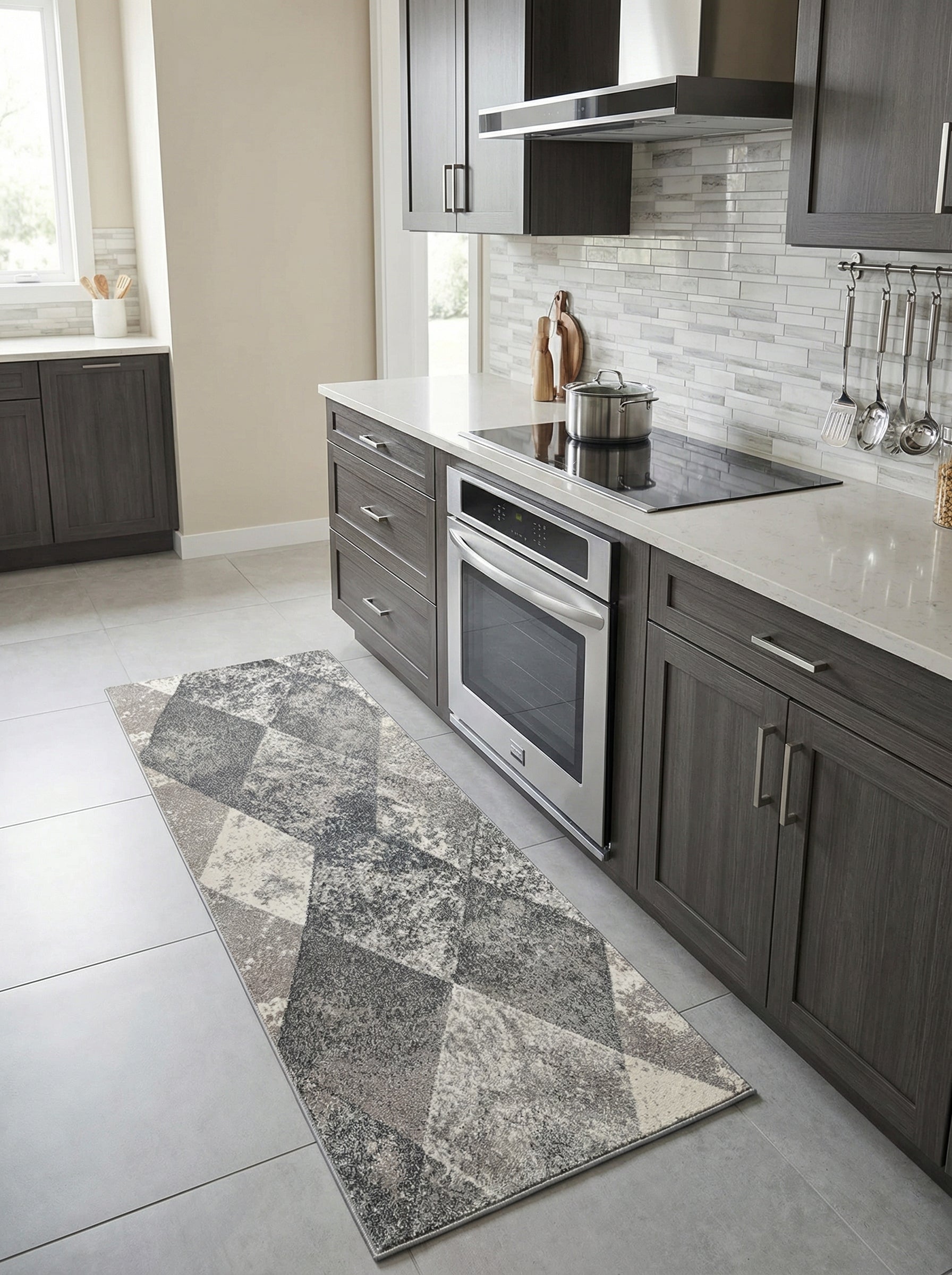 Tapis rectangulaire à motifs géométriques abstraits dans des tons gris, blancs et beiges clairs, situé dans une cuisine moderne