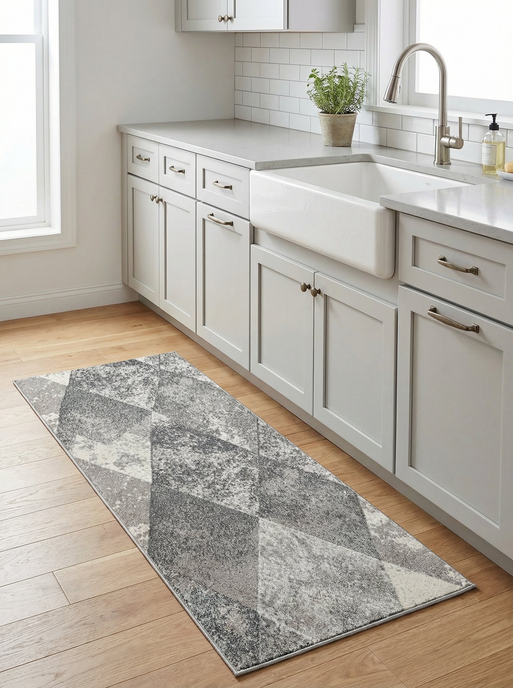Tapis de couloir gris et blanc à motifs géométriques et abstraits, posé sur un plancher en bois clair dans une cuisine moderne