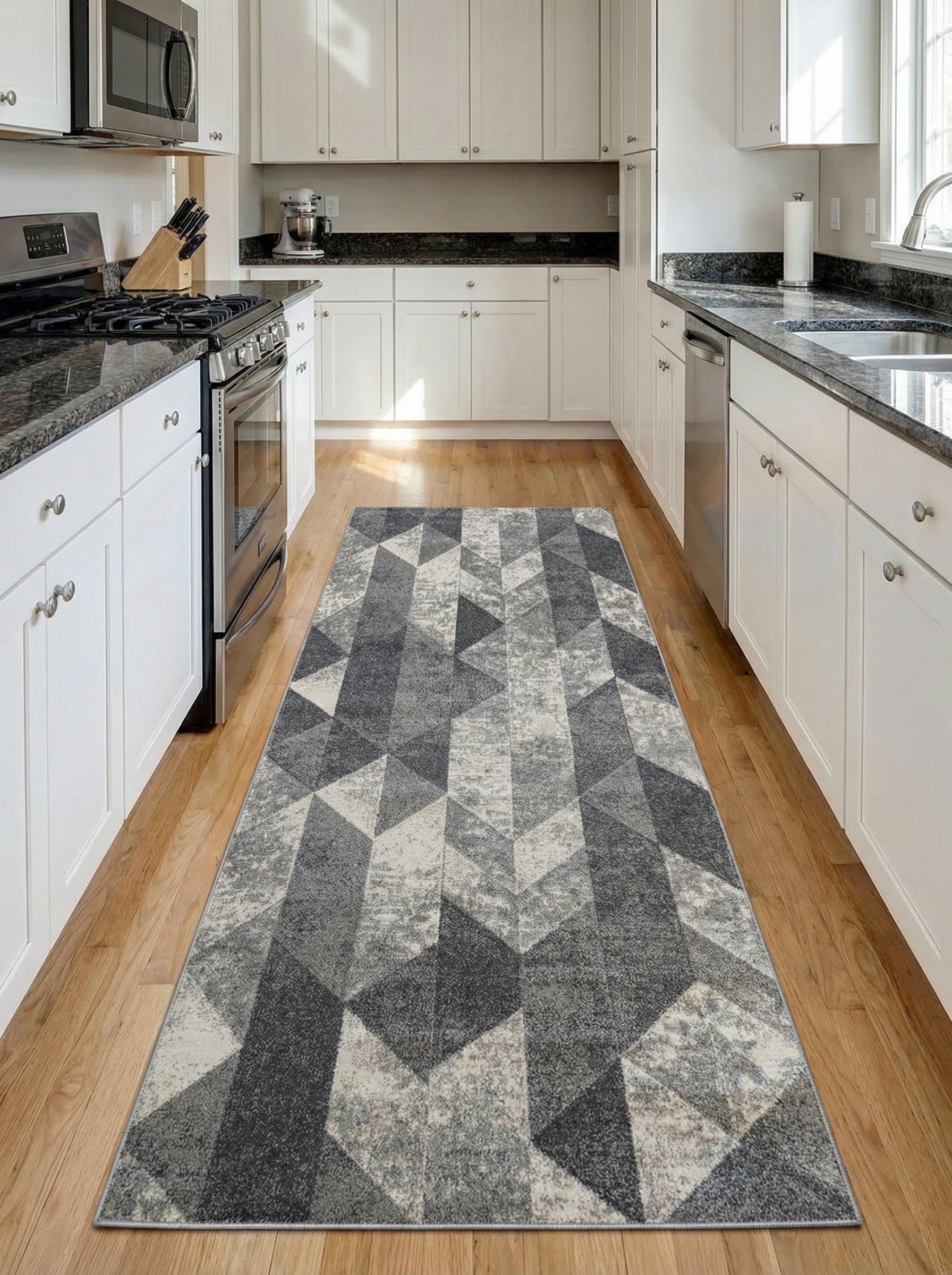 Tapis long à motifs géométriques gris foncé, gris clair et crème posé sur un plancher en bois dans une cuisine moderne
