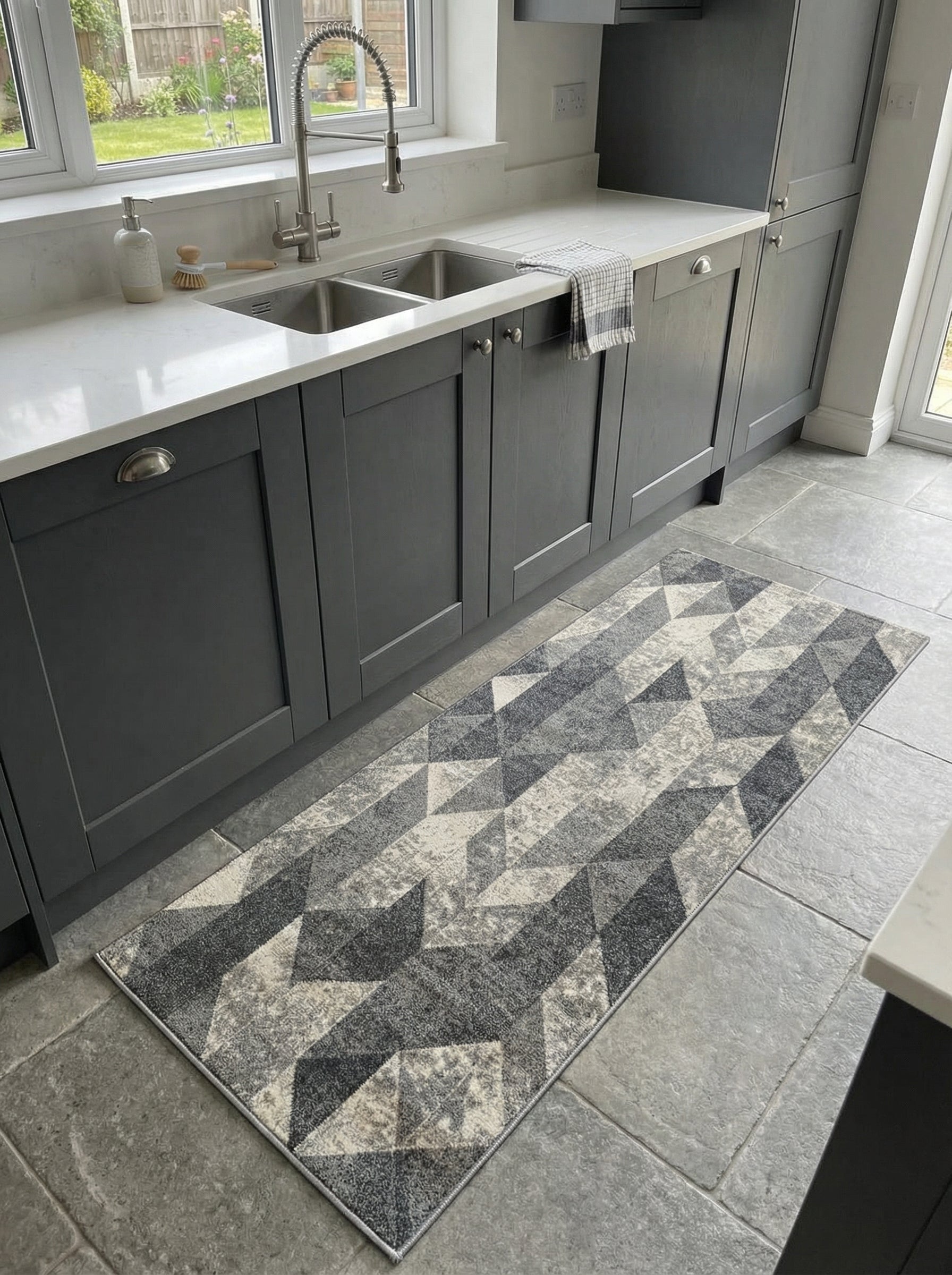 Long tapis rectangulaire à motifs géométriques d'inspiration 3D en nuances de gris et crème sur le sol d'une cuisine