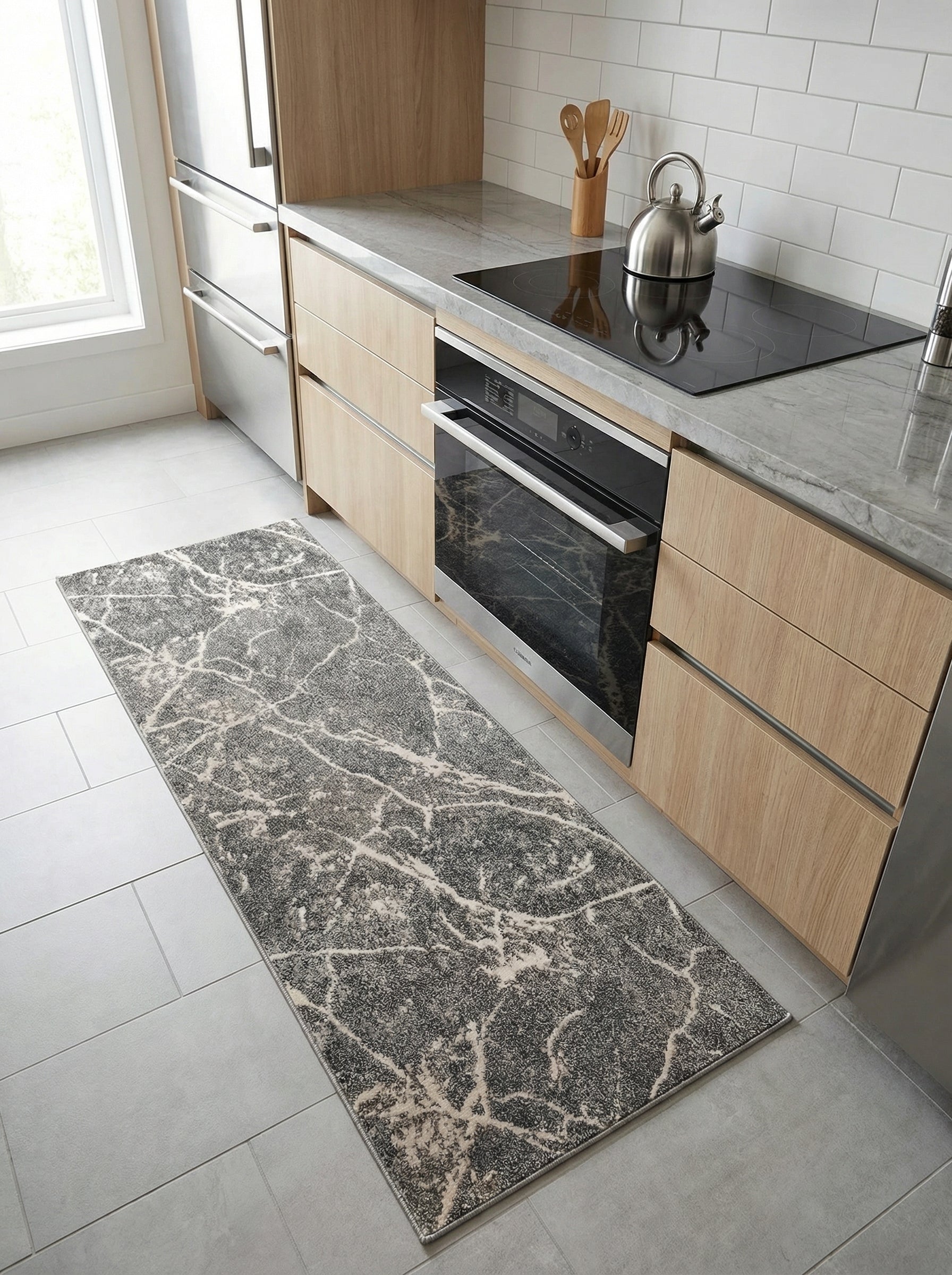 Tapis de couloir gris anthracite avec motifs marbrés clairs posé sur un sol carrelé clair dans une cuisine moderne