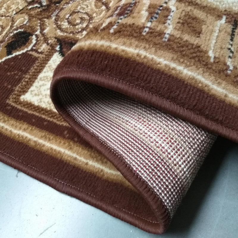 Tapis texturé marron foncé, beige et crème aux motifs ornementaux, partiellement roulé laissant voir son envers tissé