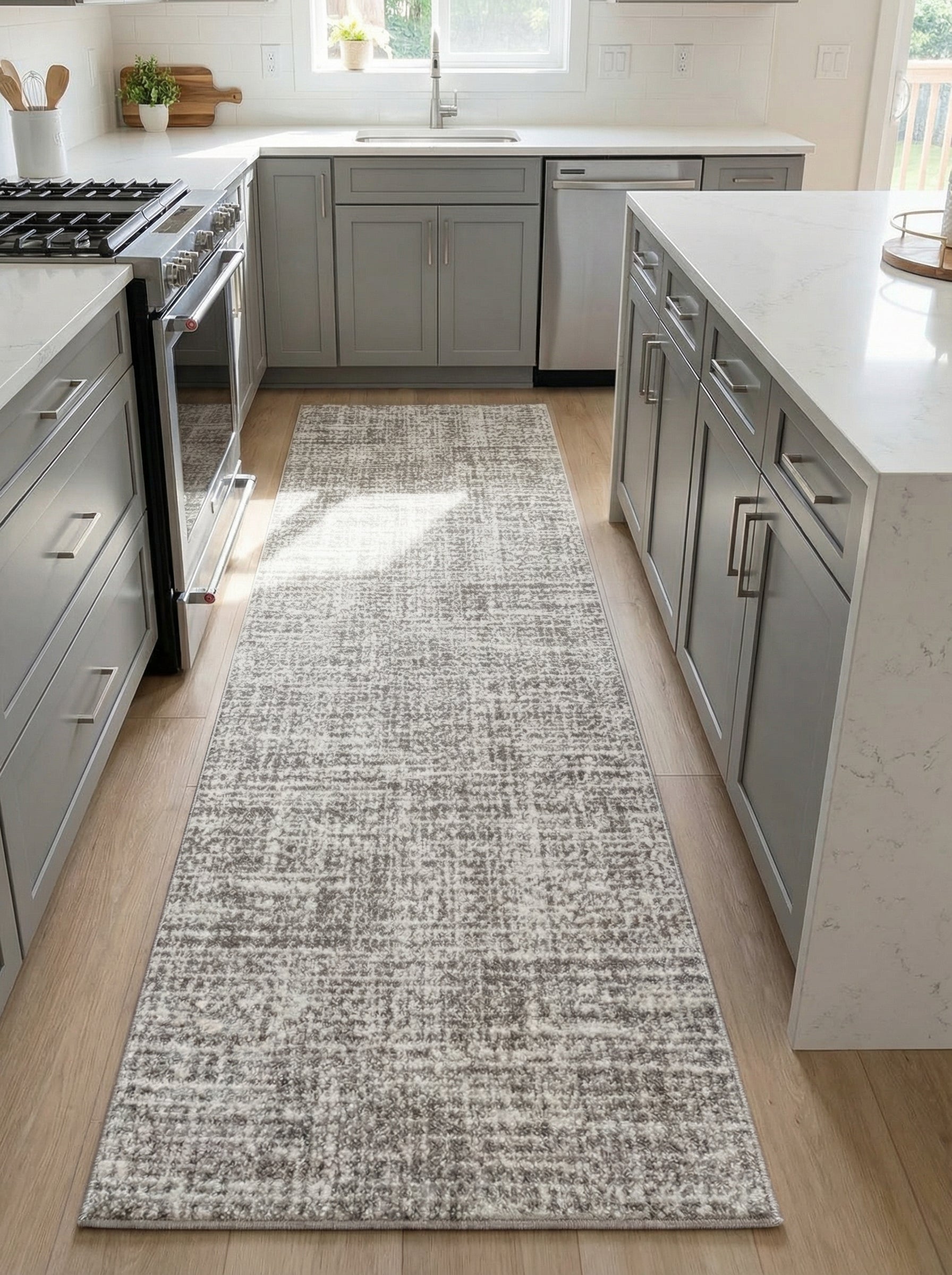 Long tapis de couloir gris clair et blanc aux motifs abstraits mouchetés, posé sur un parquet clair dans une cuisine moderne