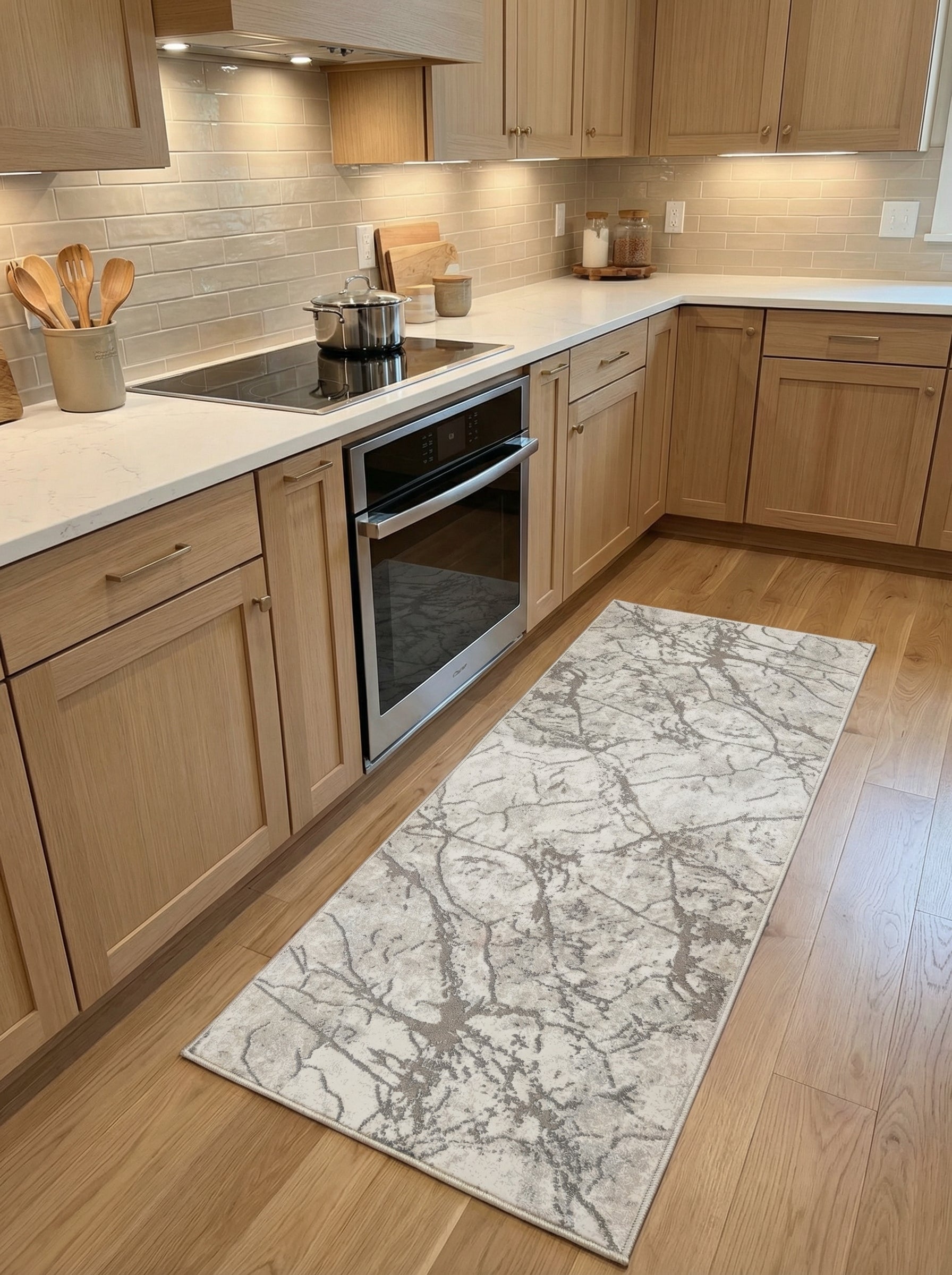 Tapis de couloir rectangulaire crème et gris, avec des motifs abstraits rappelant le marbre, posé sur un parquet en bois clair dans une cuisine moderne