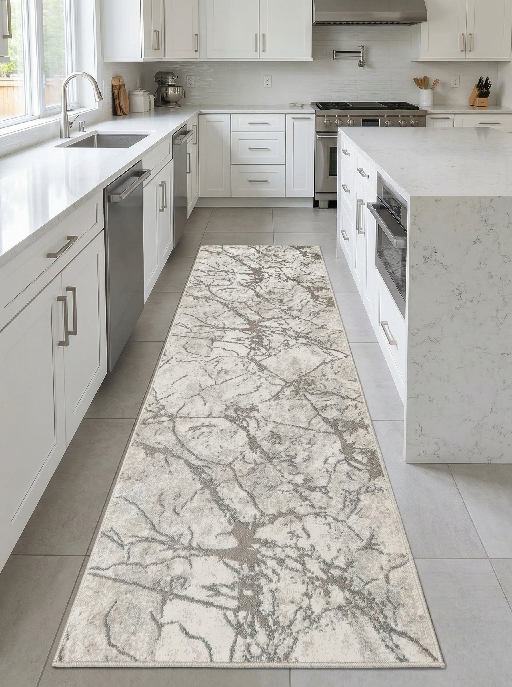 Tapis de couloir rectangulaire beige et gris à motifs abstraits de type marbré ou branches, posé sur un carrelage clair dans une cuisine moderne