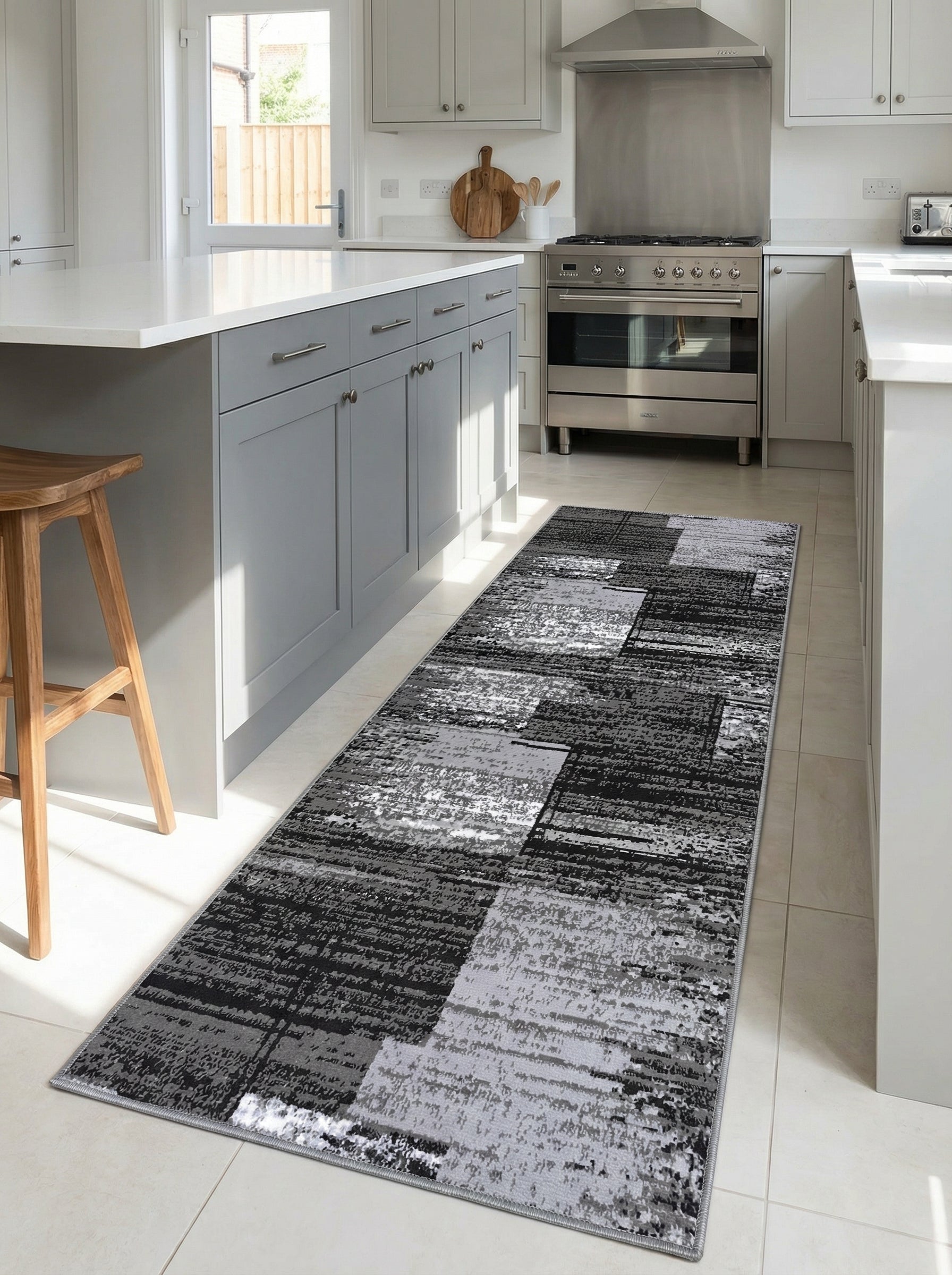 Tapis de couloir rectangulaire à motifs abstraits noirs, gris et blancs, posé sur le sol d'une cuisine moderne et lumineuse