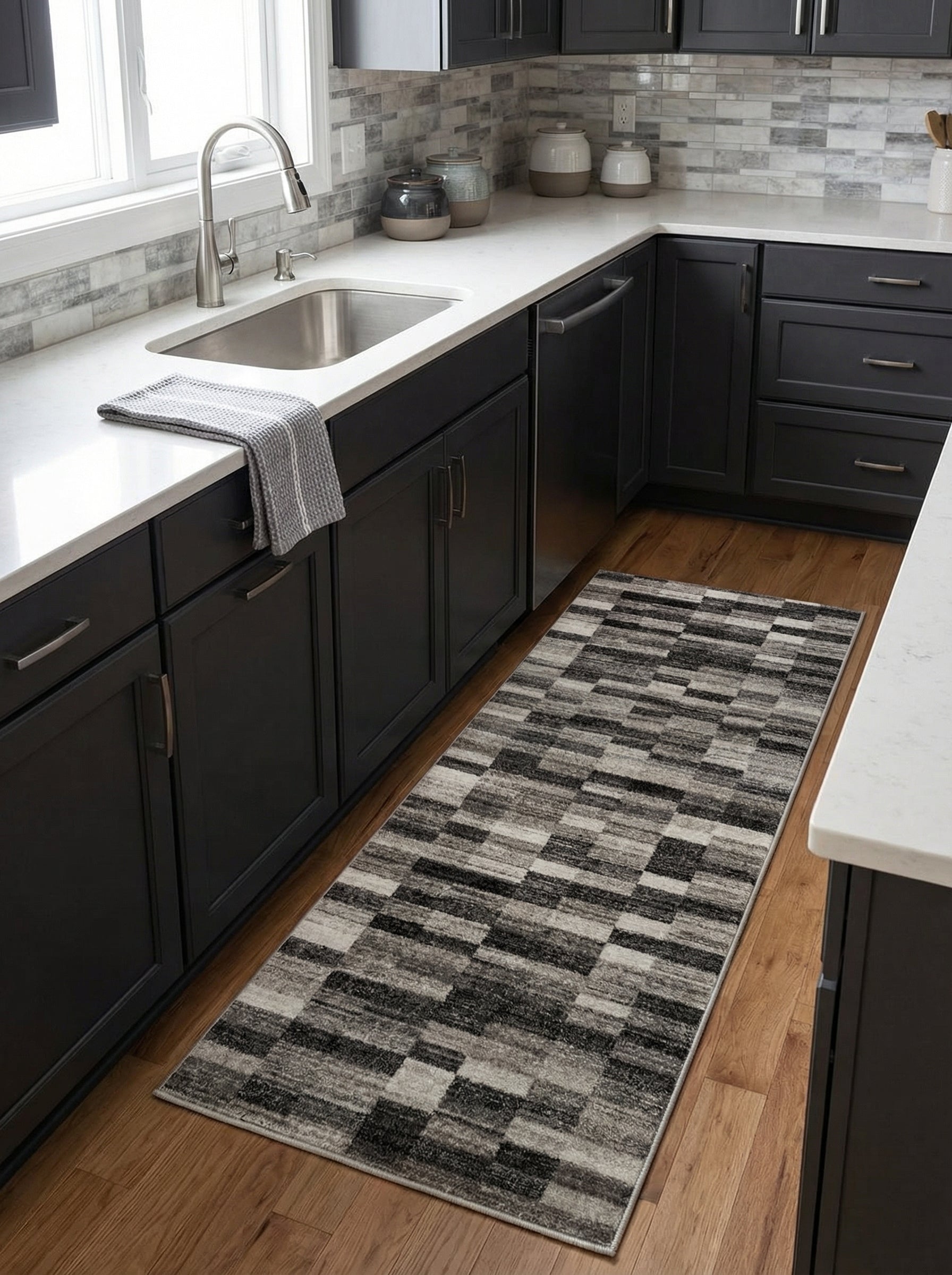 Tapis de couloir rectangulaire à motifs géométriques abstraits gris, noirs et blancs, sur un plancher en bois dans une cuisine