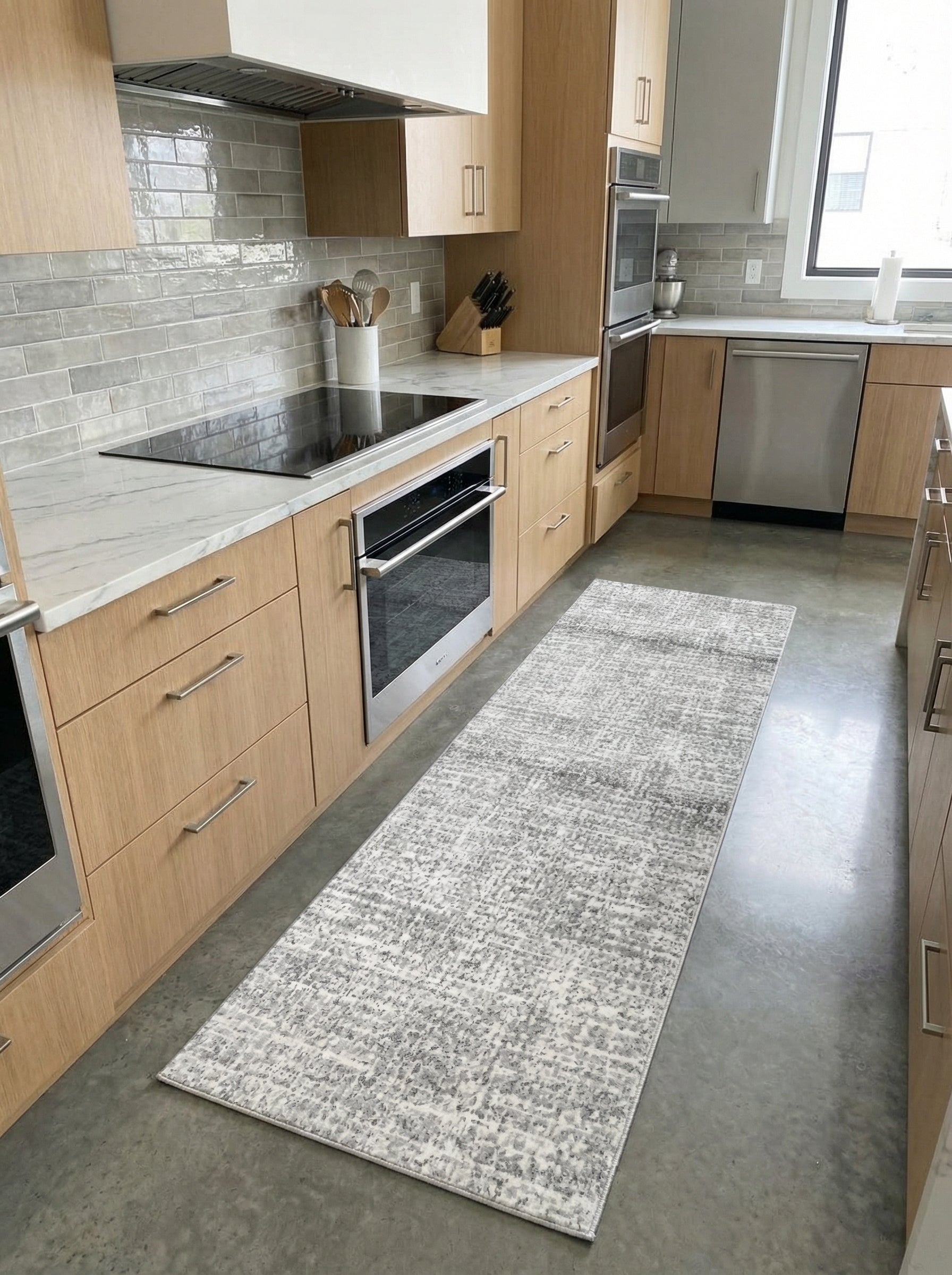 Tapis de couloir rectangulaire gris et blanc aux motifs abstraits, posé sur le sol d'une cuisine moderne
