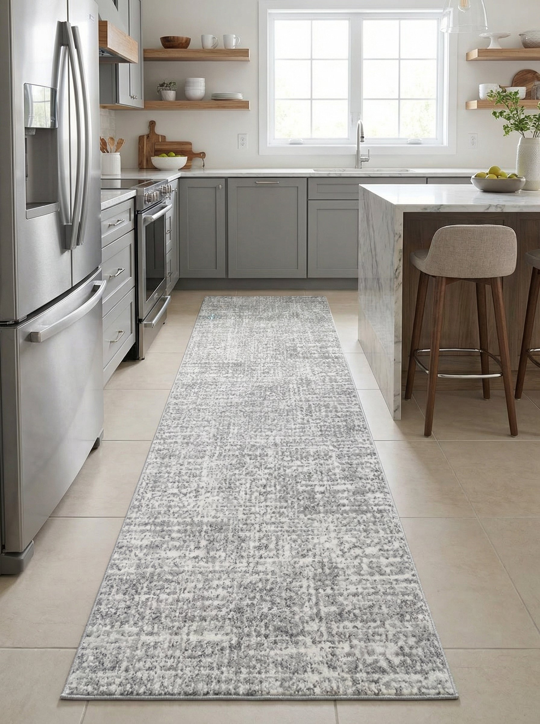 Tapis de couloir rectangulaire aux motifs abstraits gris et blancs effet vieilli, posé sur un sol carrelé dans une cuisine moderne