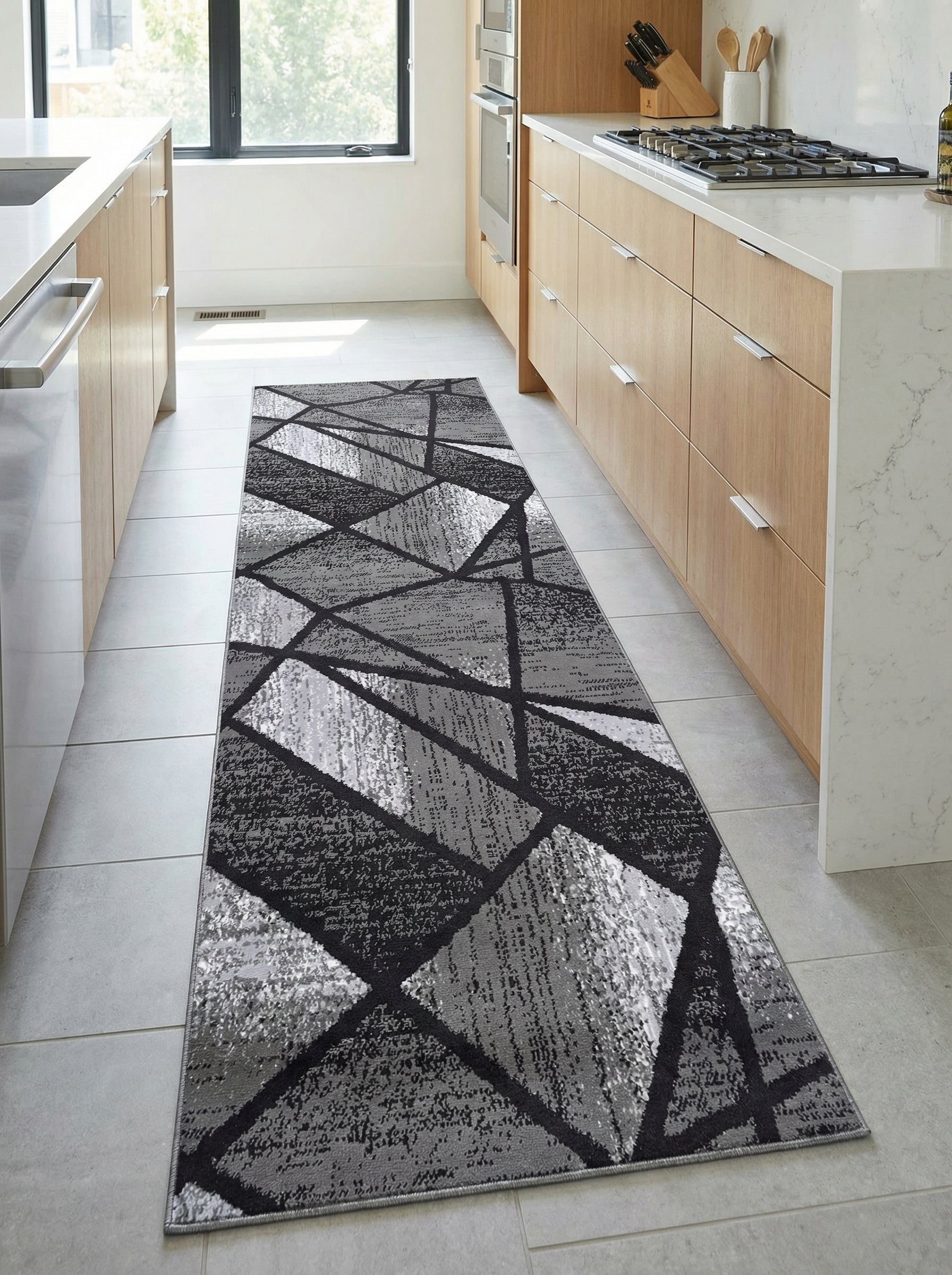 Tapis de couloir rectangulaire gris et noir avec motif géométrique abstrait, aux textures variées, posé dans une cuisine moderne